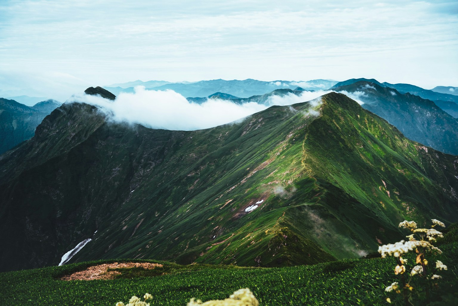 Lush green mountains with clouds in the background