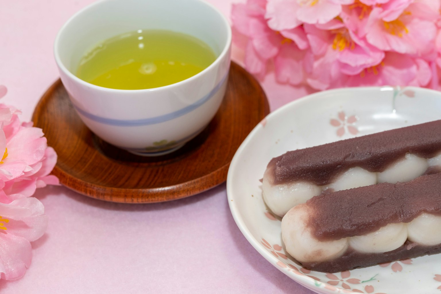 Presentazione di tè verde e dolci giapponesi con decorazioni di fiori di ciliegio