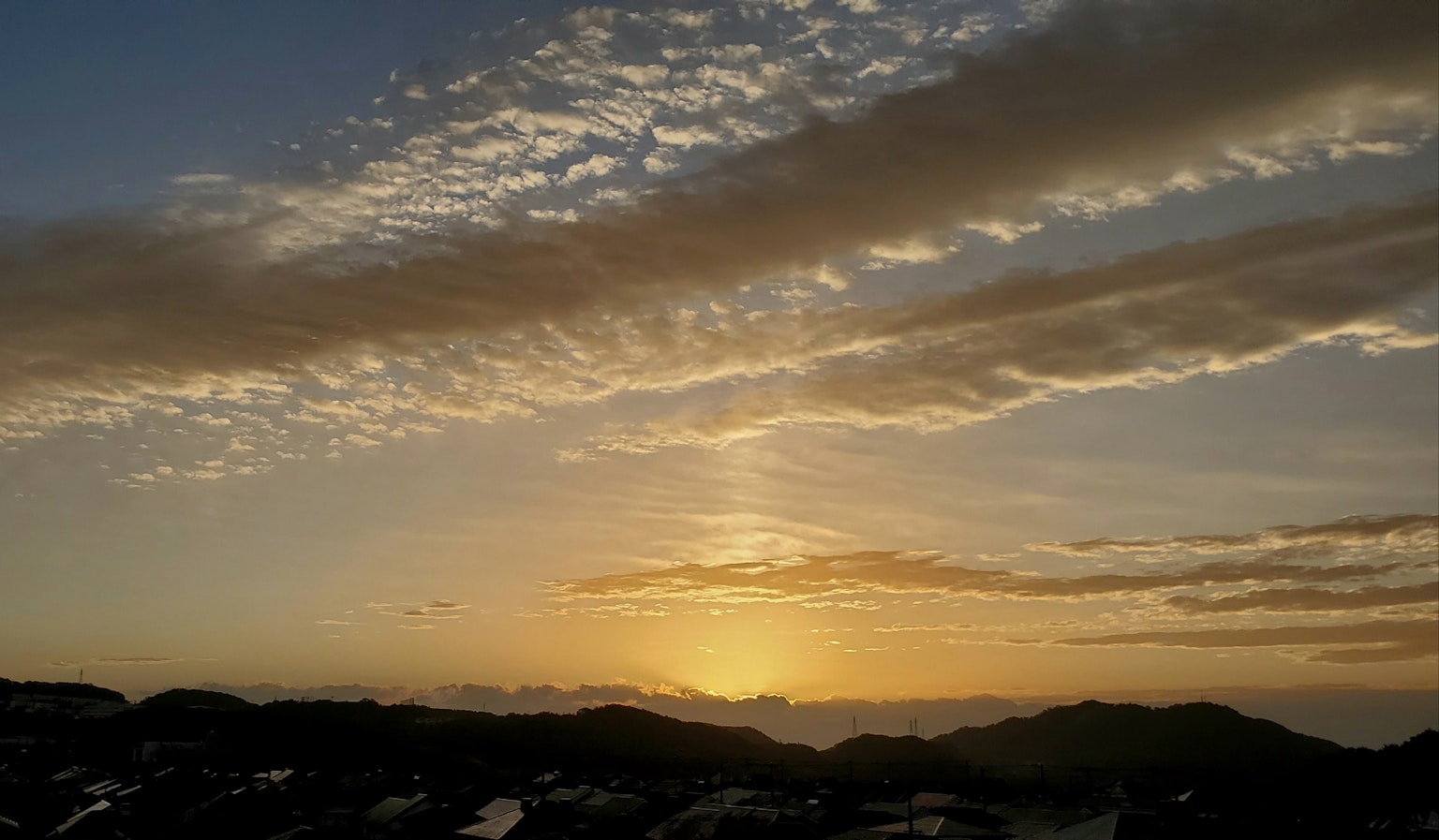 Beautiful sunset landscape with layers of clouds and mountain silhouettes