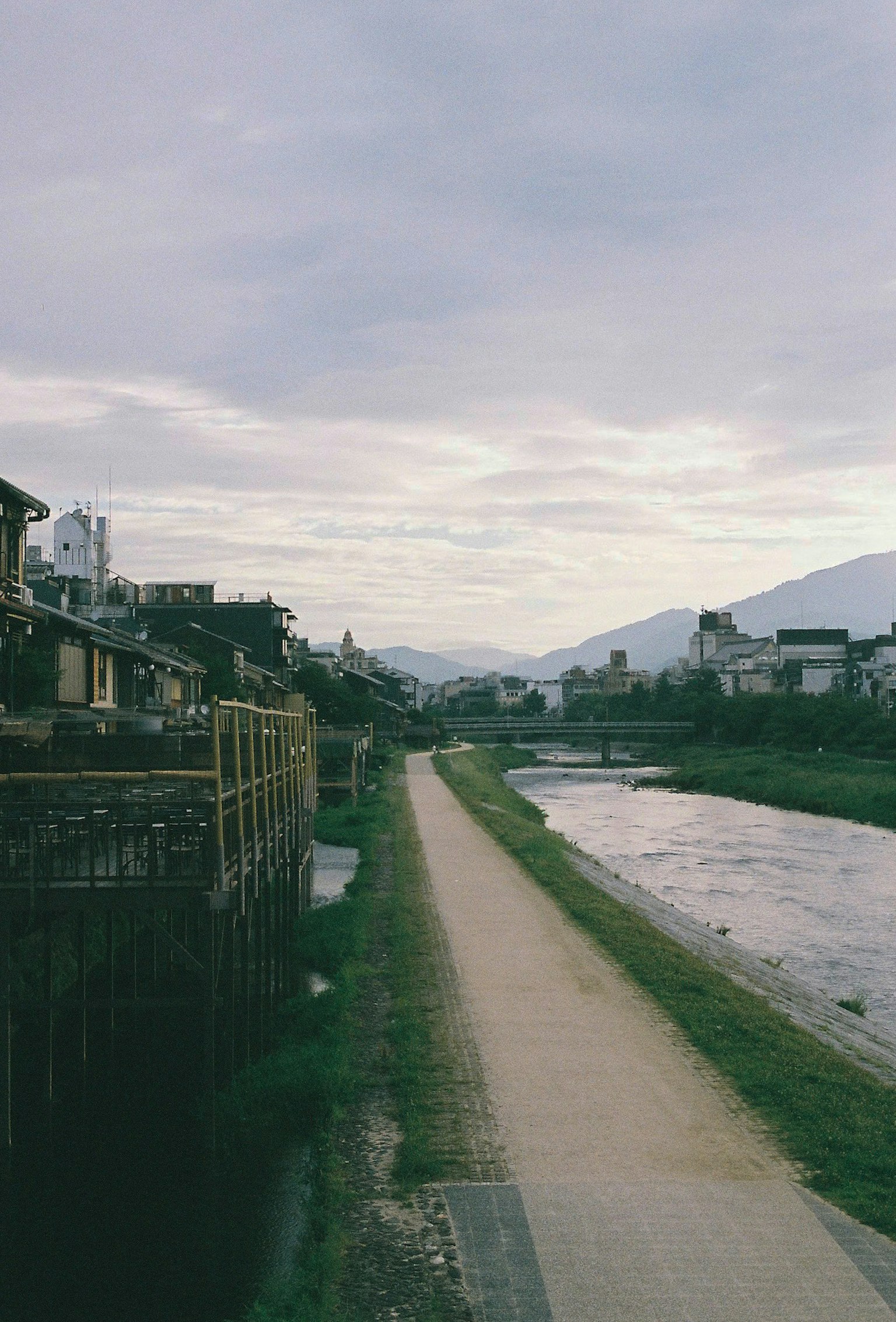 静かな川のそばの小道と建物の風景