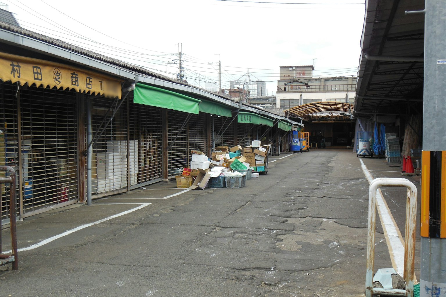狹窄街道旁是封閉的商店和散落的貨物
