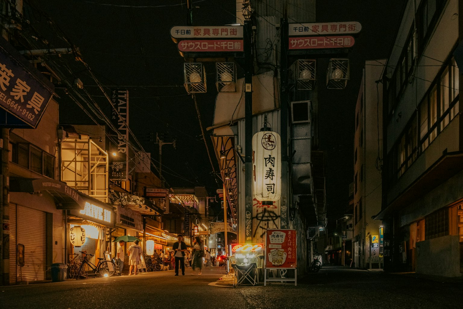 Japanische Einkaufsstraße bei Nacht mit beleuchteten Schildern