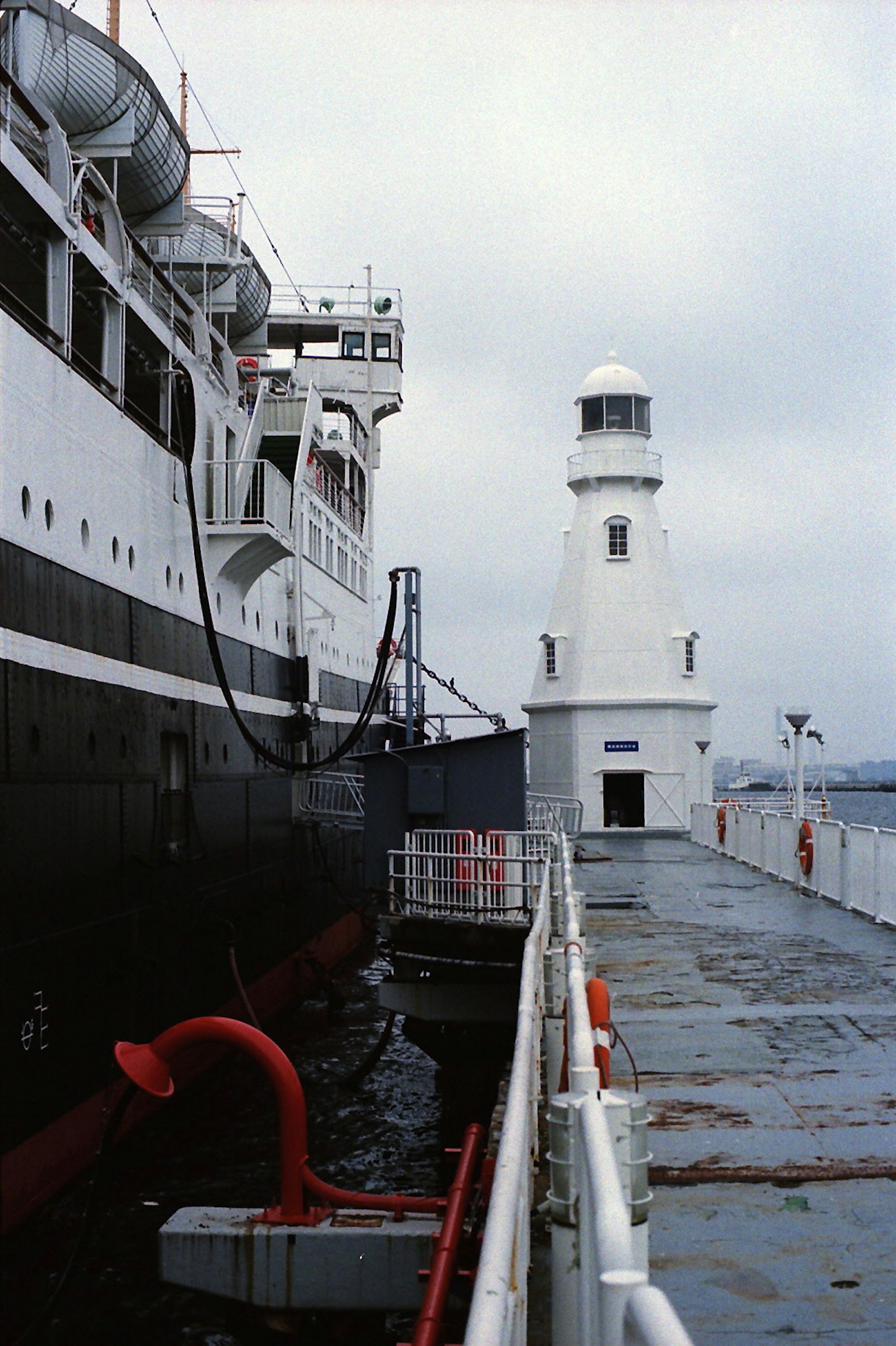 Una scena portuale con una nave e un faro