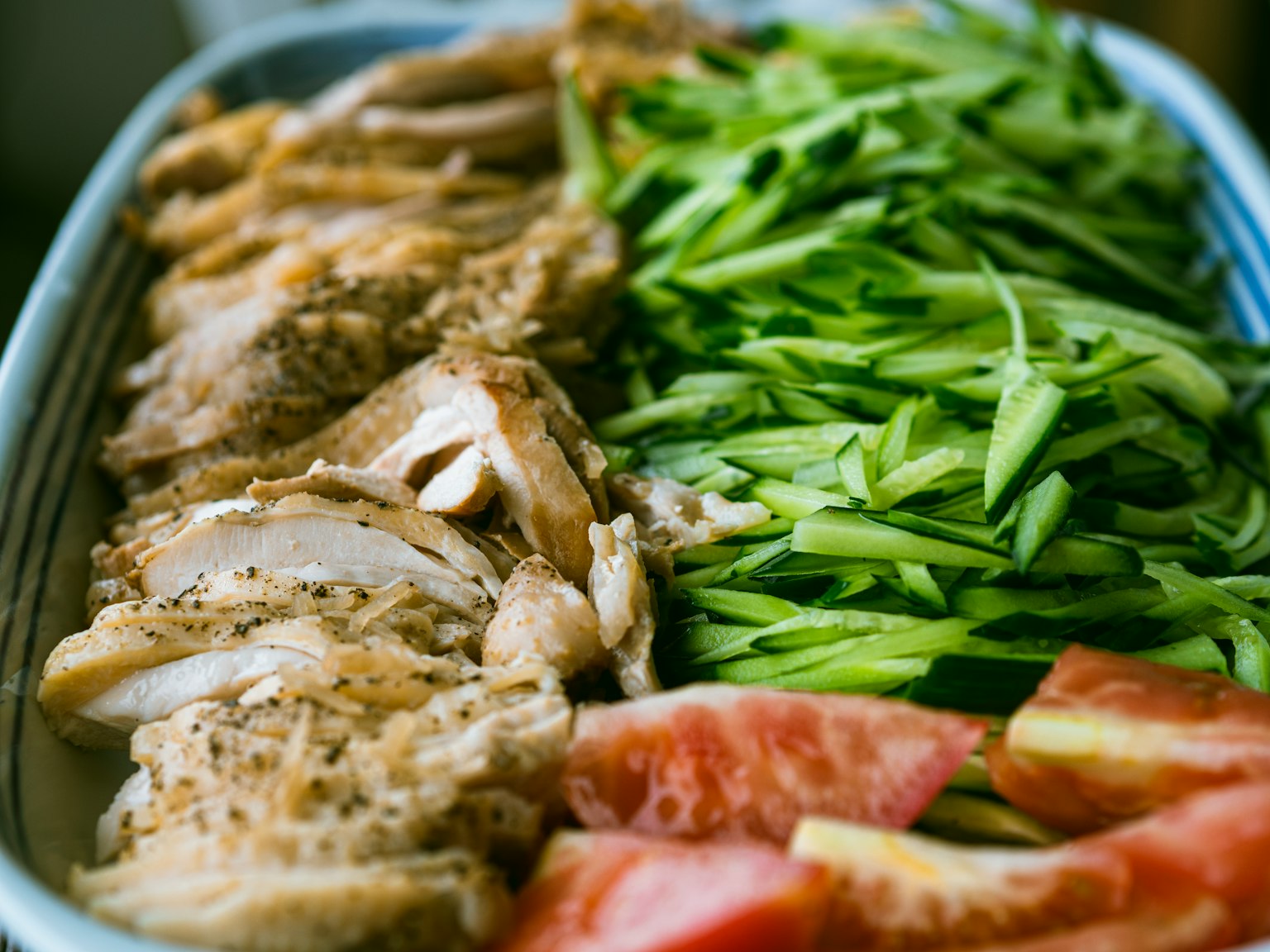 Pollo affettato con cipollotti tritati e fette di pomodoro