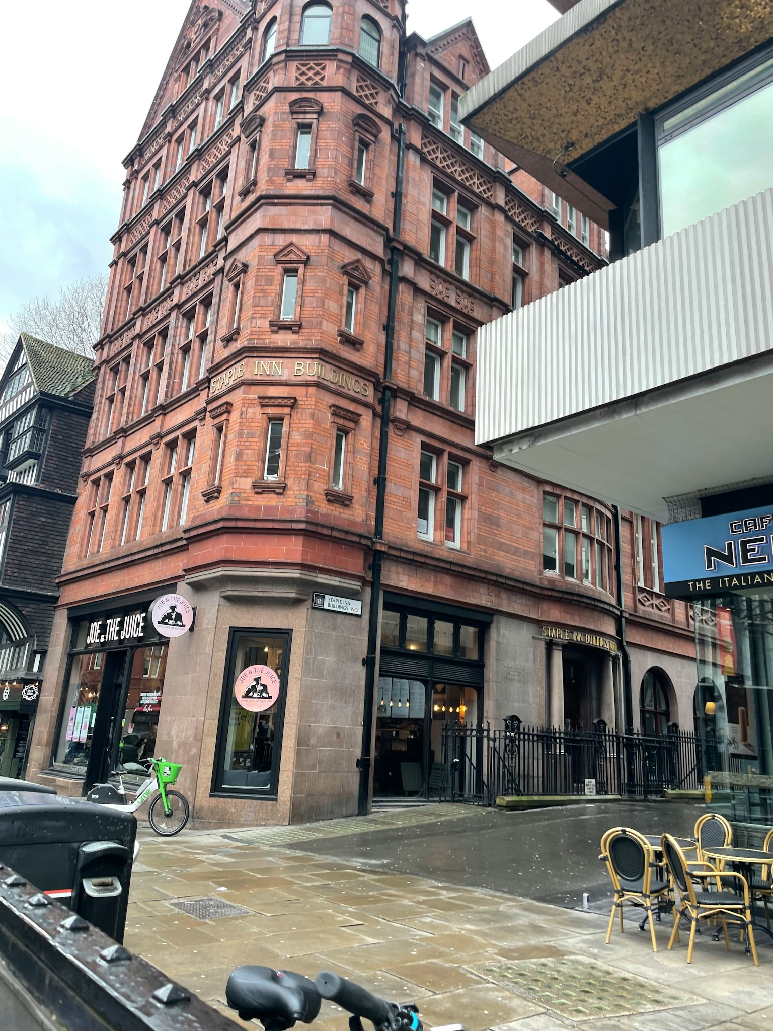 Vue d'angle de rue avec un bâtiment en briques rouges et une façade moderne
