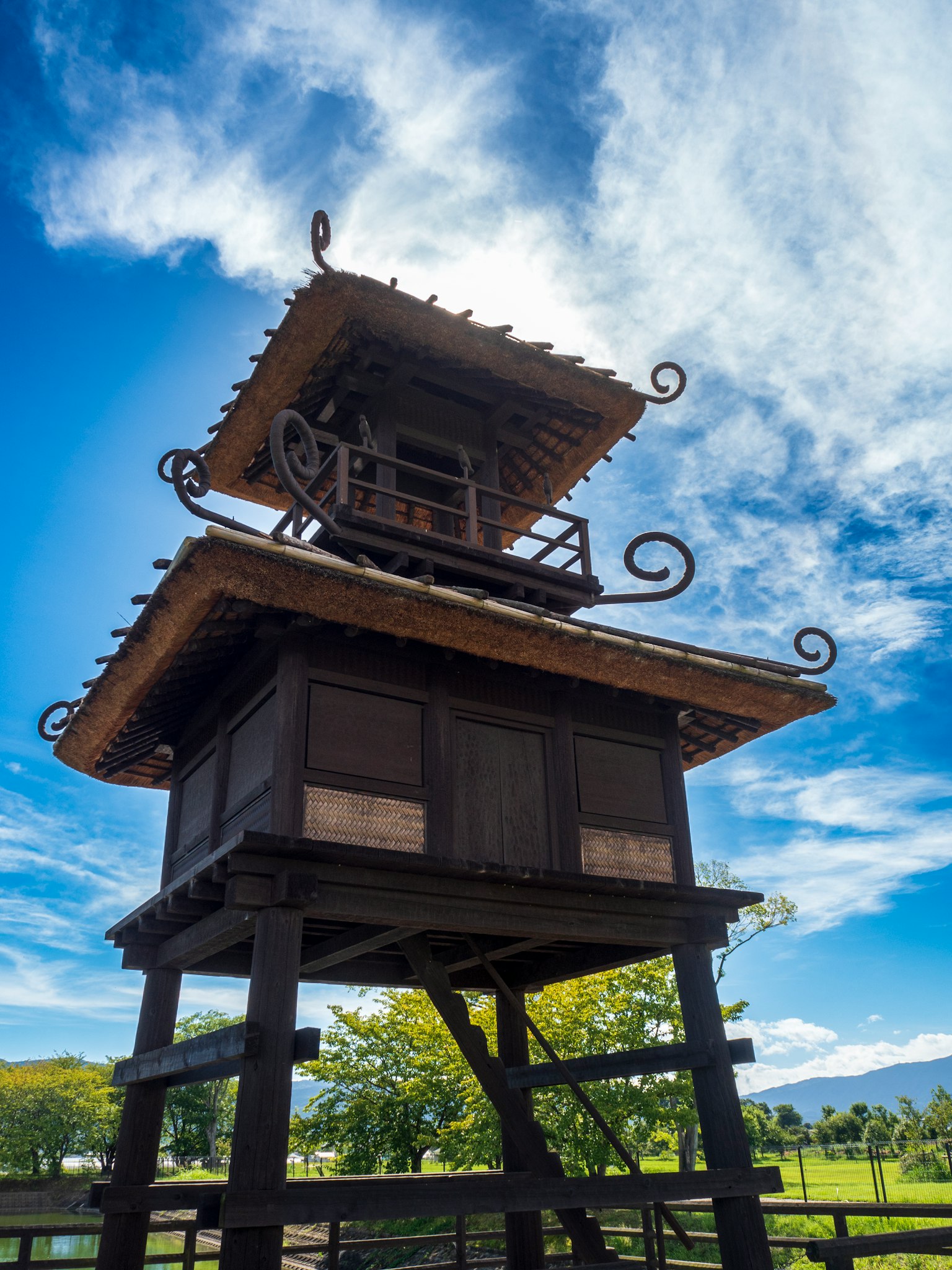 Struktur menara kayu tradisional di bawah langit biru