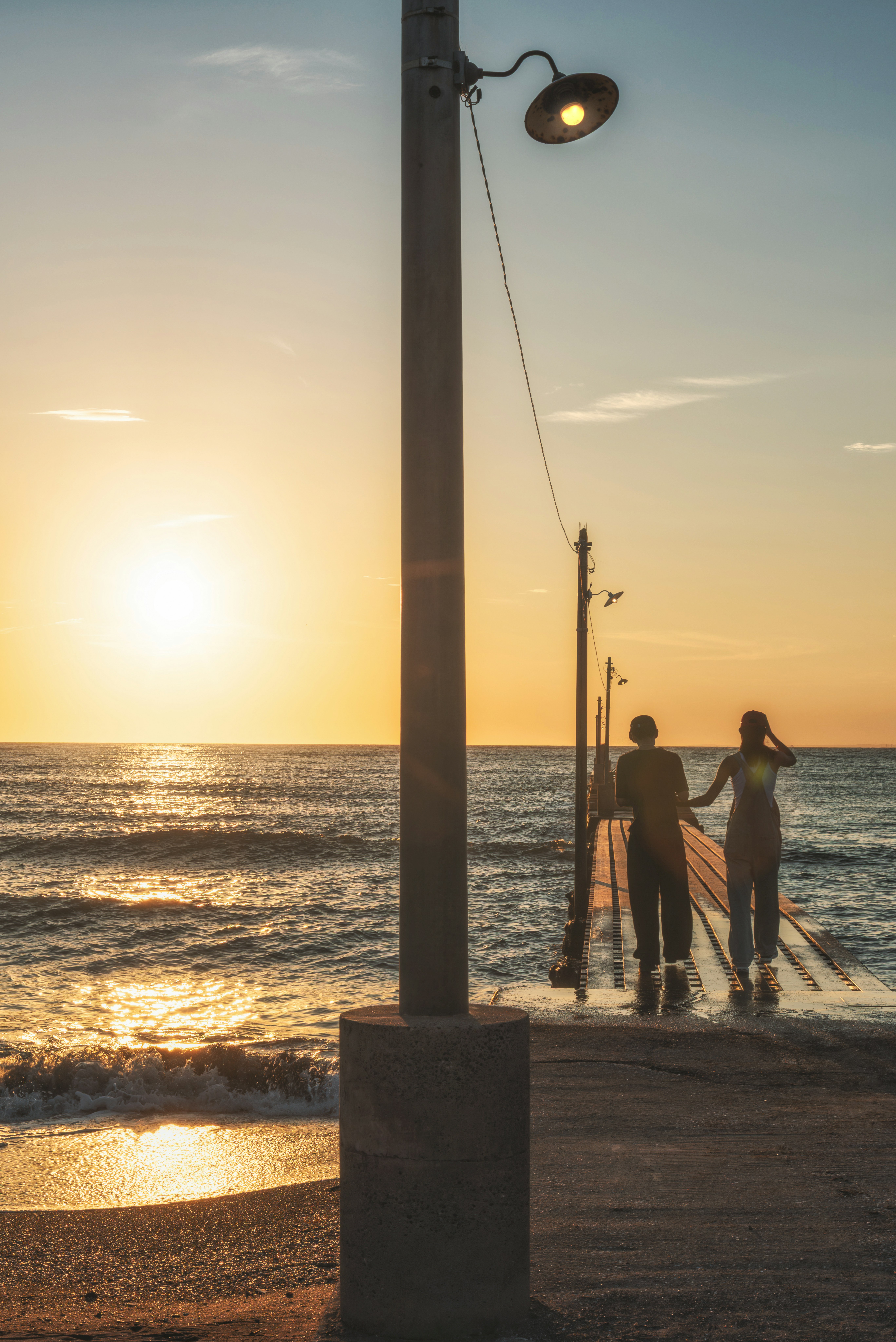 silhouettes of people by the seaside at sunset