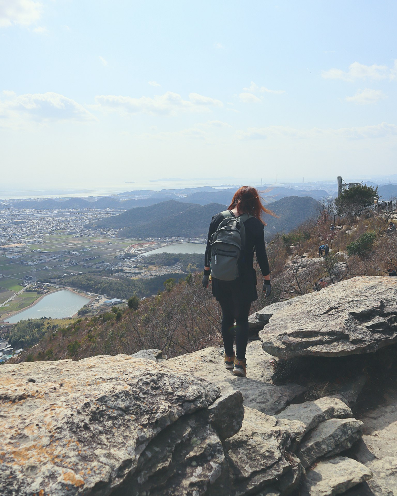 A woman hiking towards the mountain summit with a scenic view