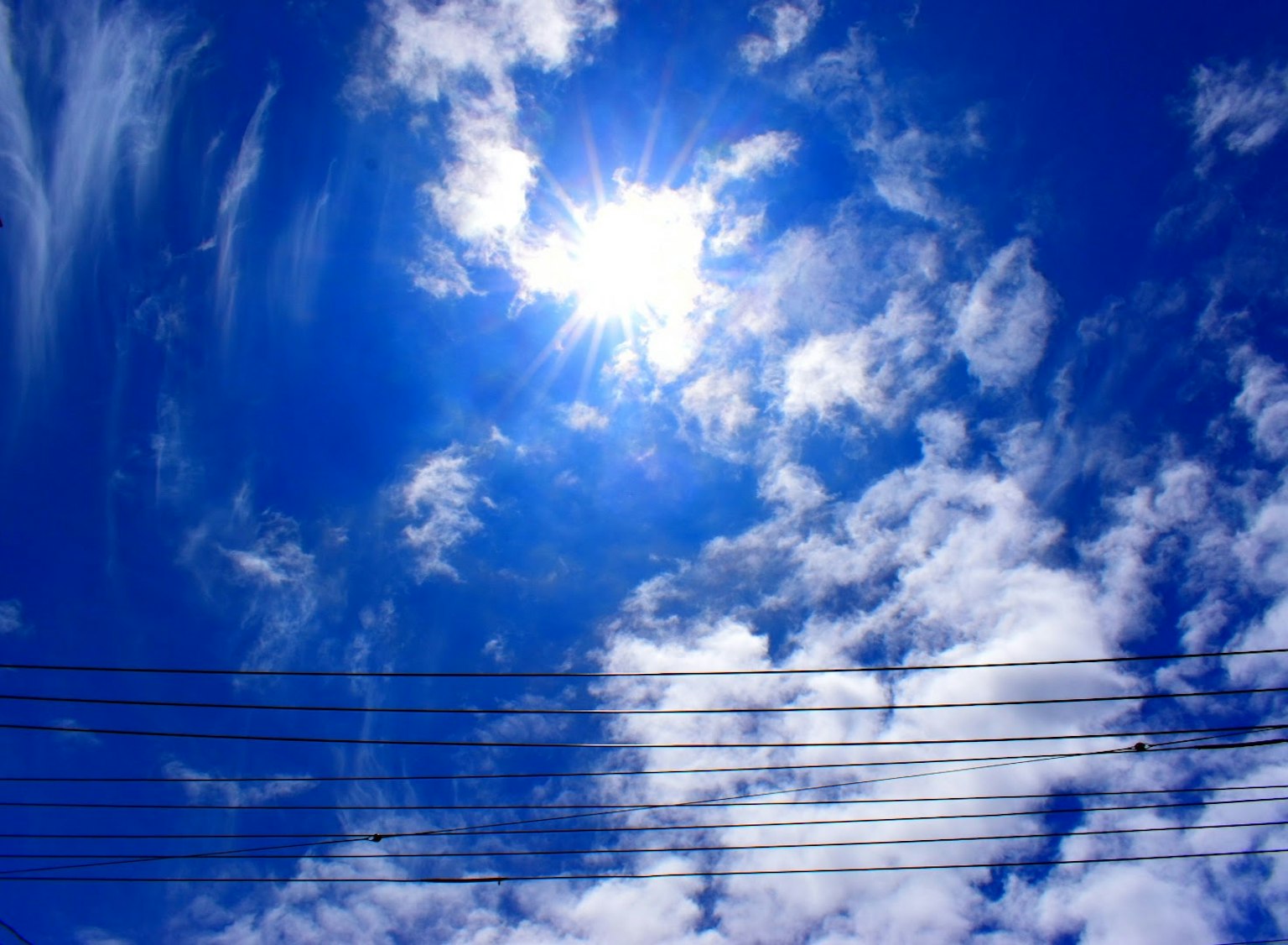 Cielo blu brillante con nuvole bianche e sole splendente