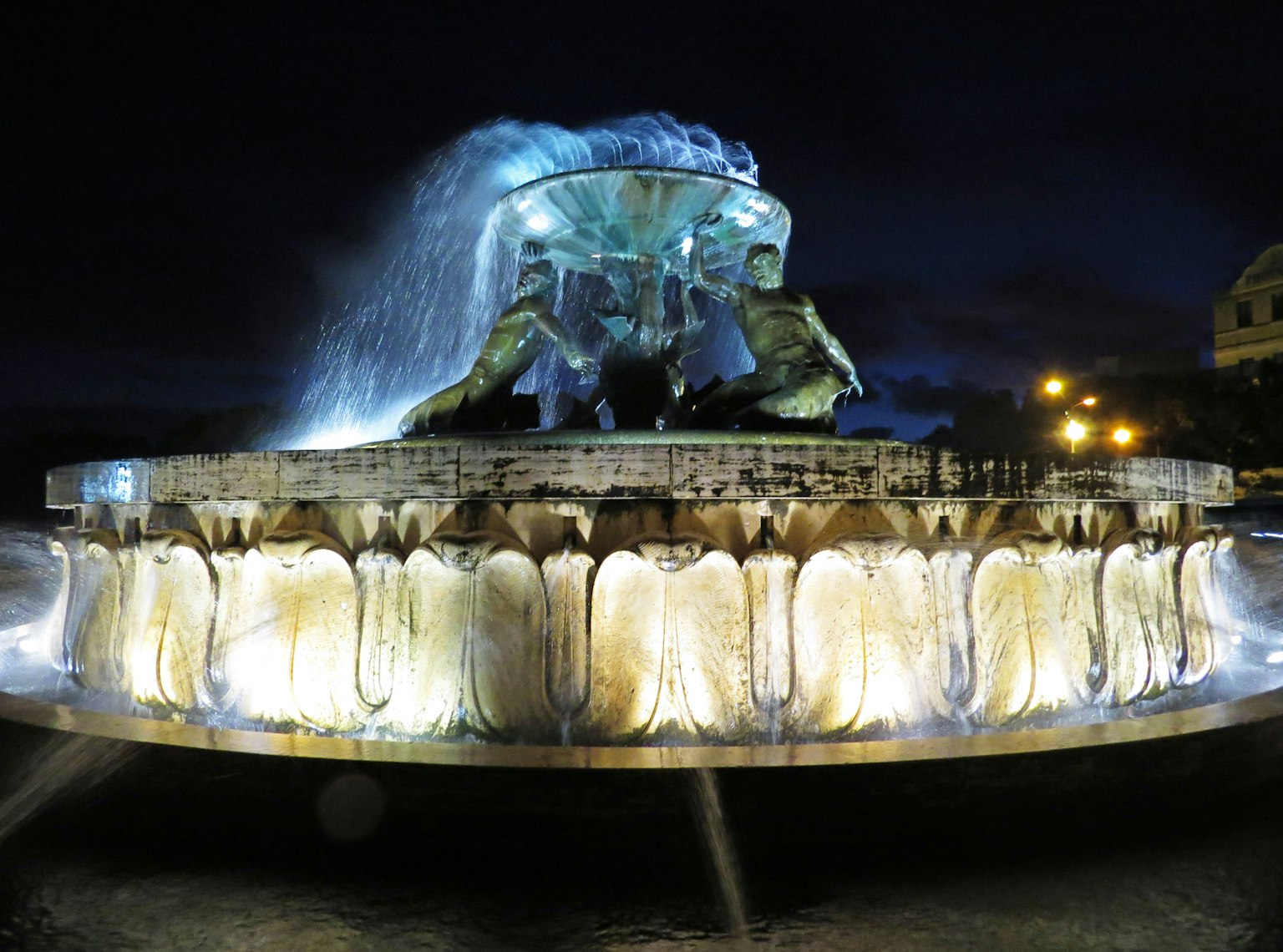 Eine beeindruckende Nachtansicht eines Brunnens mit Wasserfall