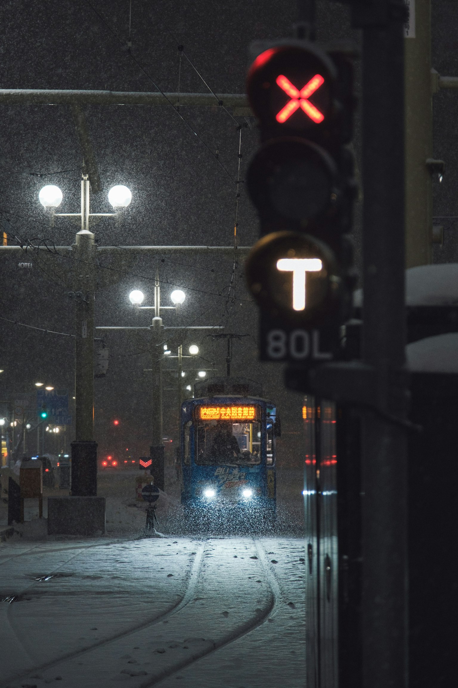 눈 속의 교통 신호와 접근하는 트램