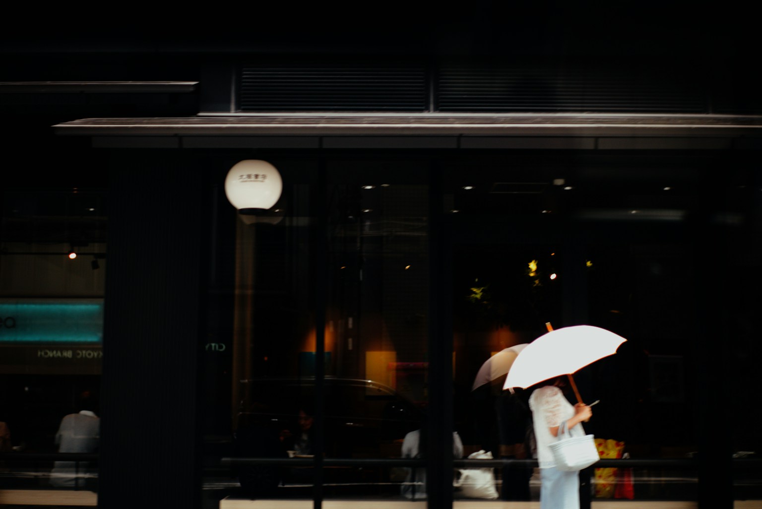 A woman holding an umbrella standing against a dark background