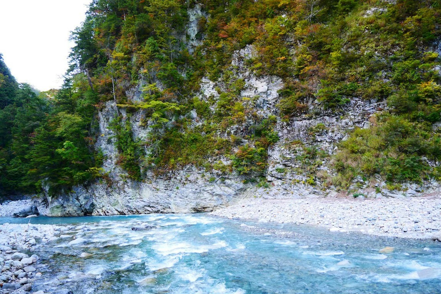 美丽的景观，蓝色河流被绿色树木和岩石悬崖环绕