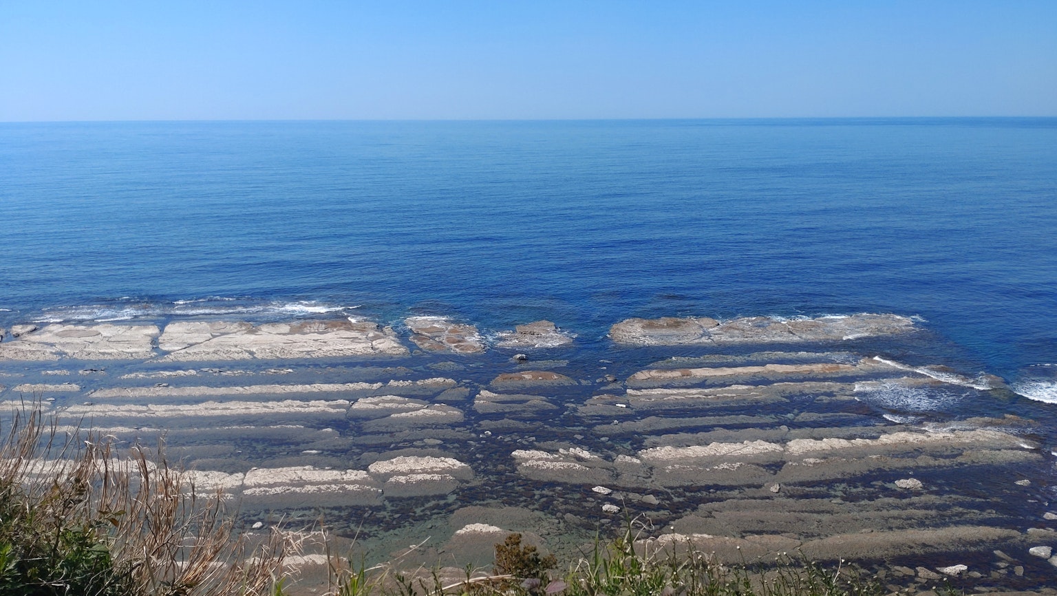 Panoramablick auf einen blauen Ozean und Felsformationen