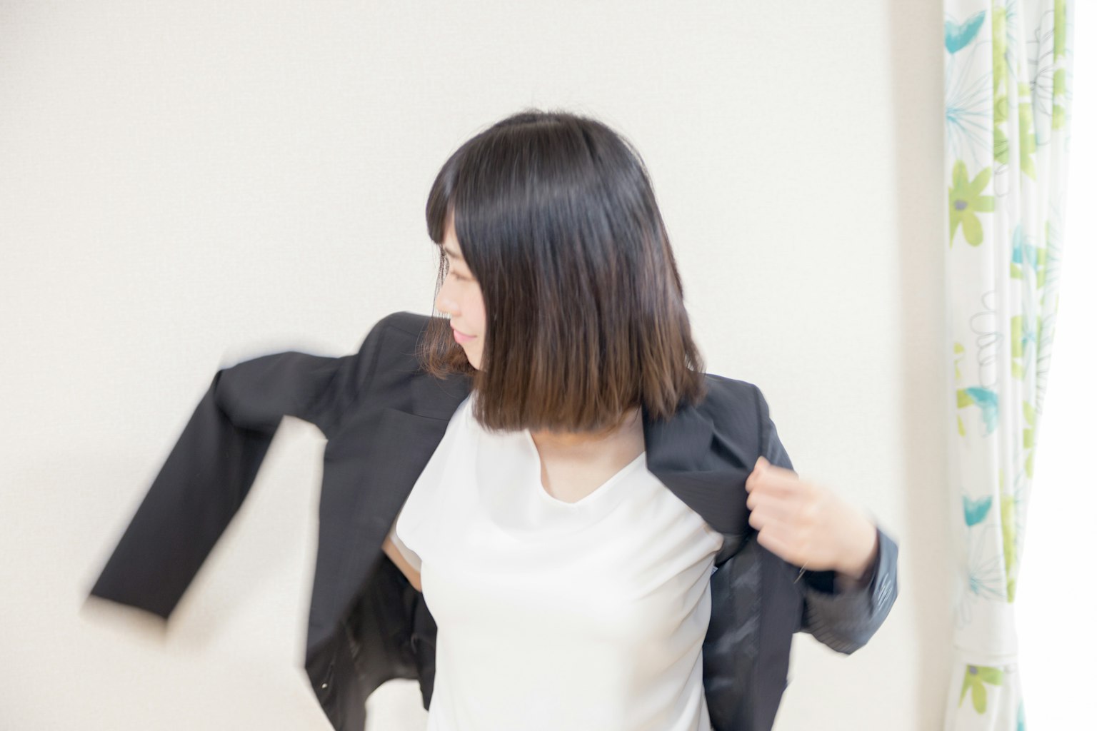 Mujer poniéndose una chaqueta negra sobre una camiseta blanca