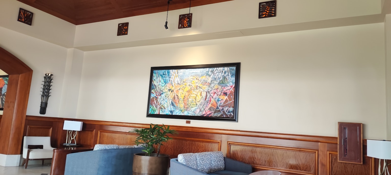 Modernes Wohnzimmer mit farbenfrohem Kunstwerk an der Wand und gemütlichen Möbeln