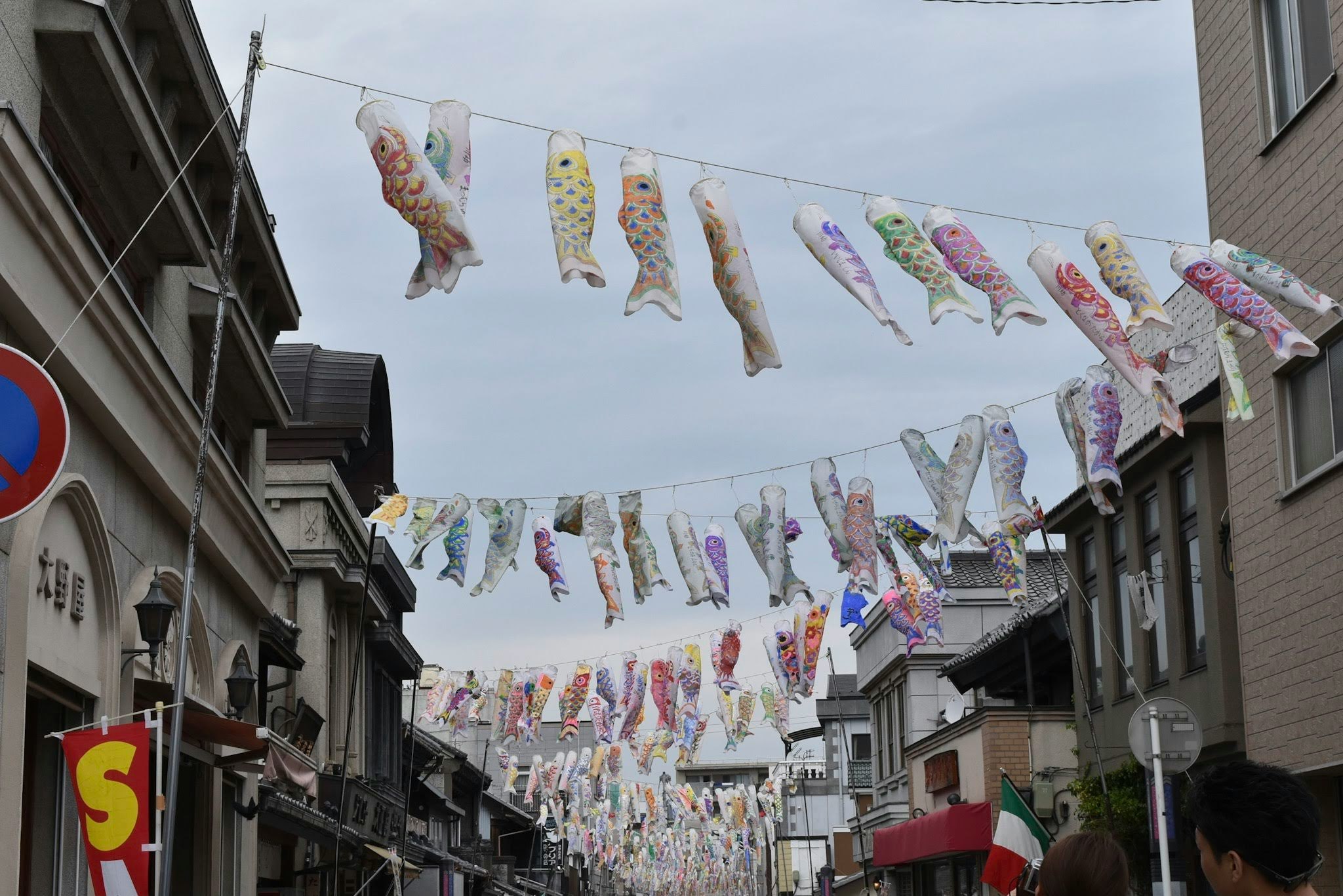 colorful fish-shaped streamers hanging over a narrow street