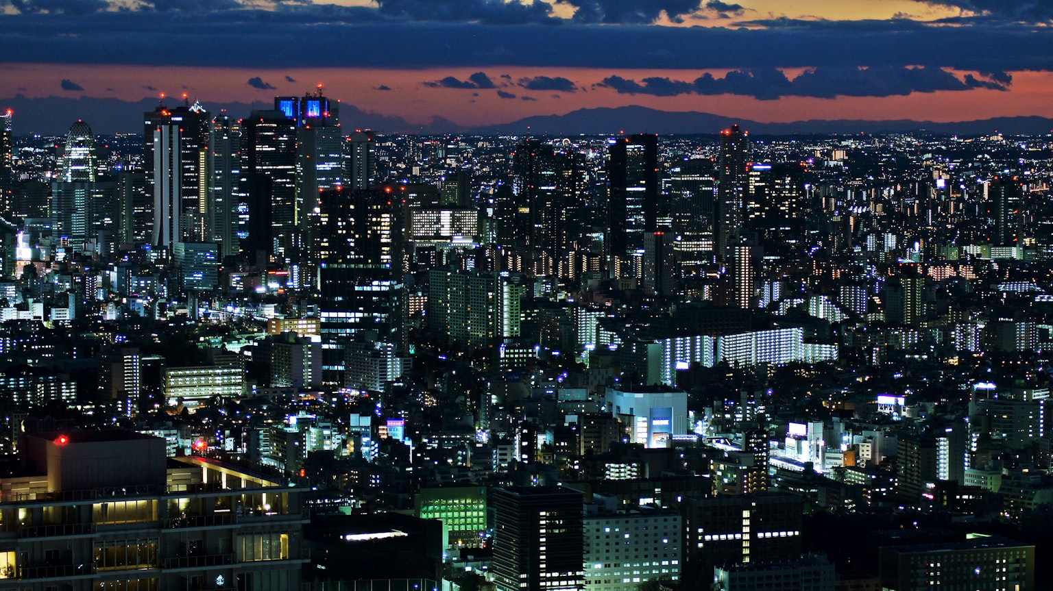 Pemandangan malam Tokyo dengan gedung pencakar langit dan lampu cerah