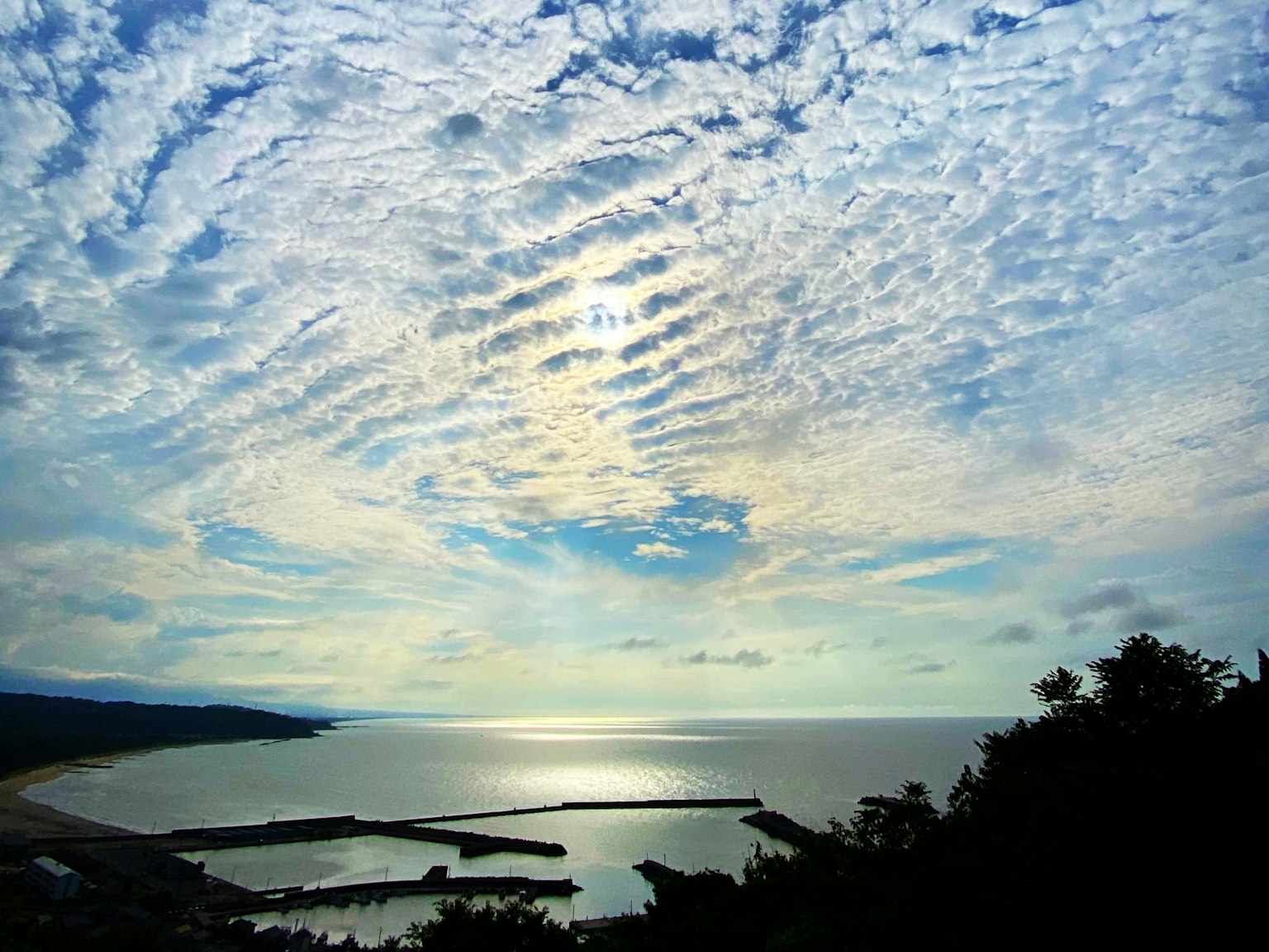 Scenic view of blue ocean under a sky filled with white clouds