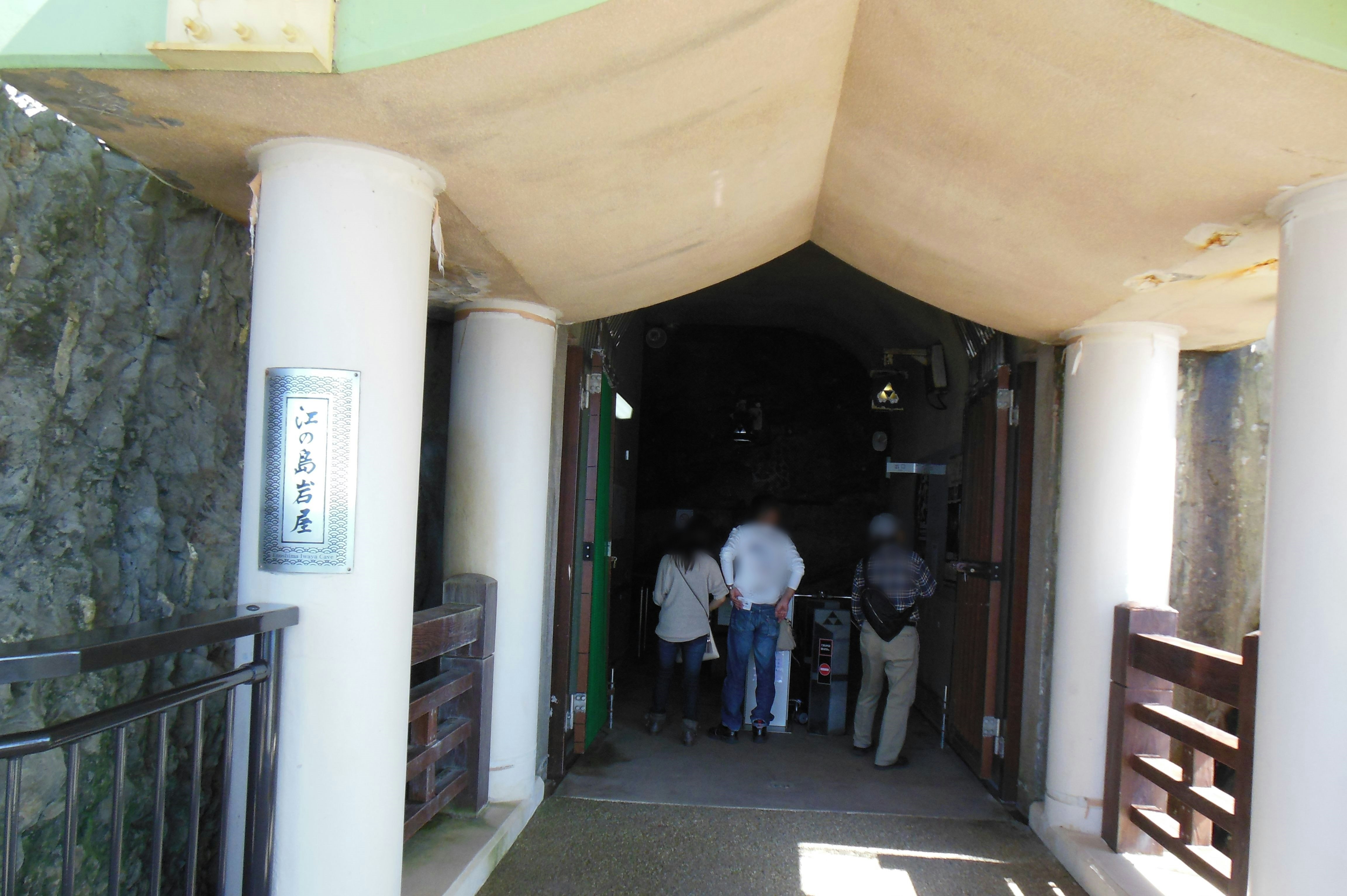 Entrée d’un passage étroit avec mur en pierre et colonnes