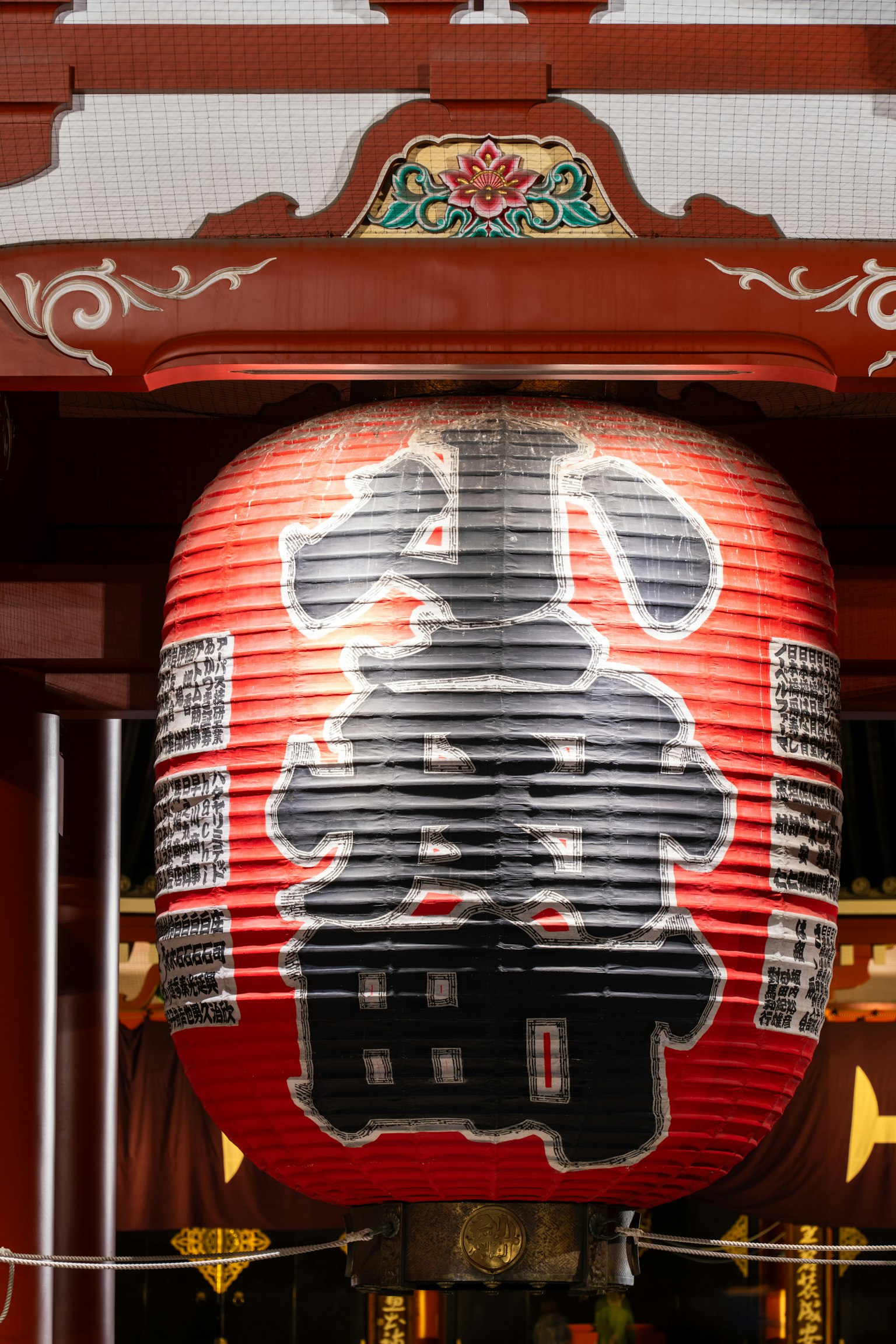 Entrée d'un temple avec une grande lanterne rouge et des caractères noirs