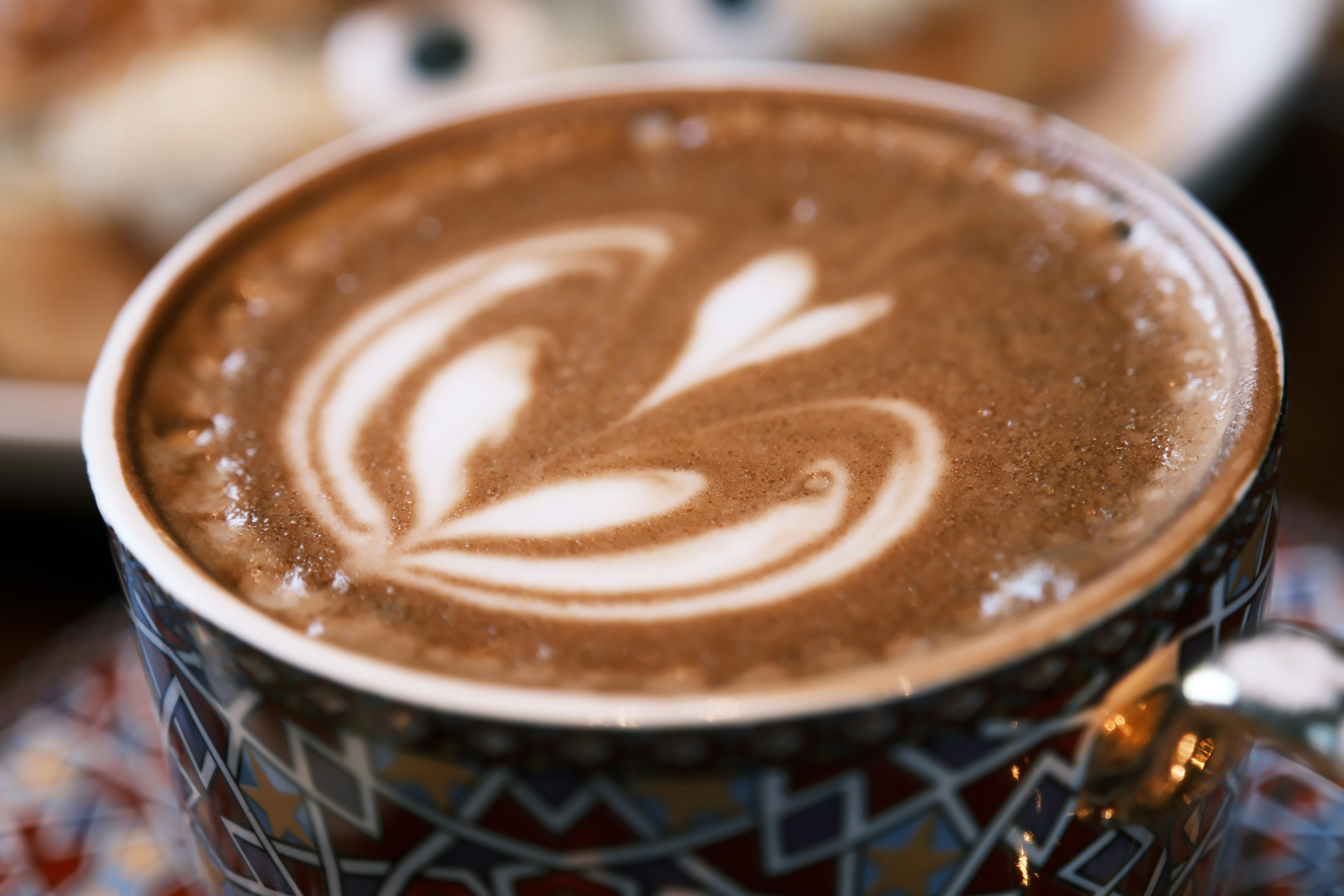 Nahaufnahme von einem Kaffee mit Latte-Art im Becher Bild