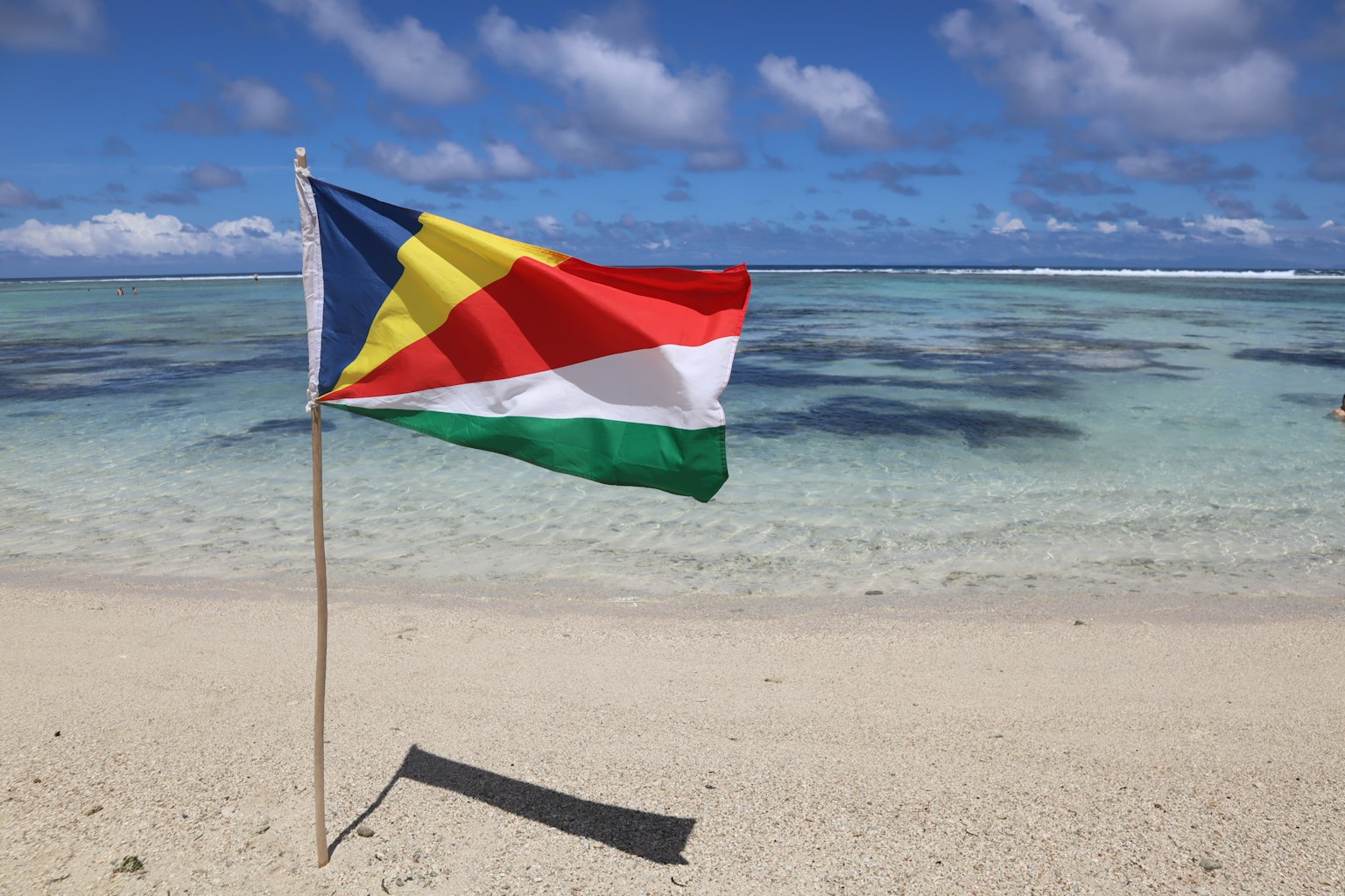Cờ Seychelles bay trên bãi biển với nước màu ngọc lam