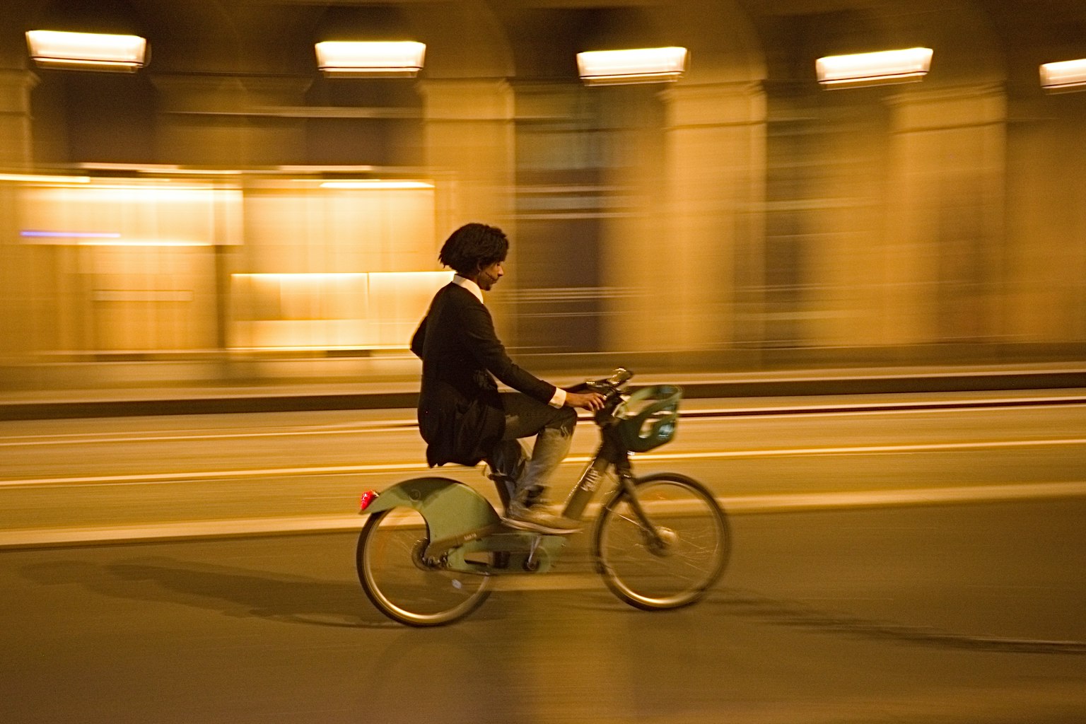 一個人在夜晚的城市街道上騎自行車