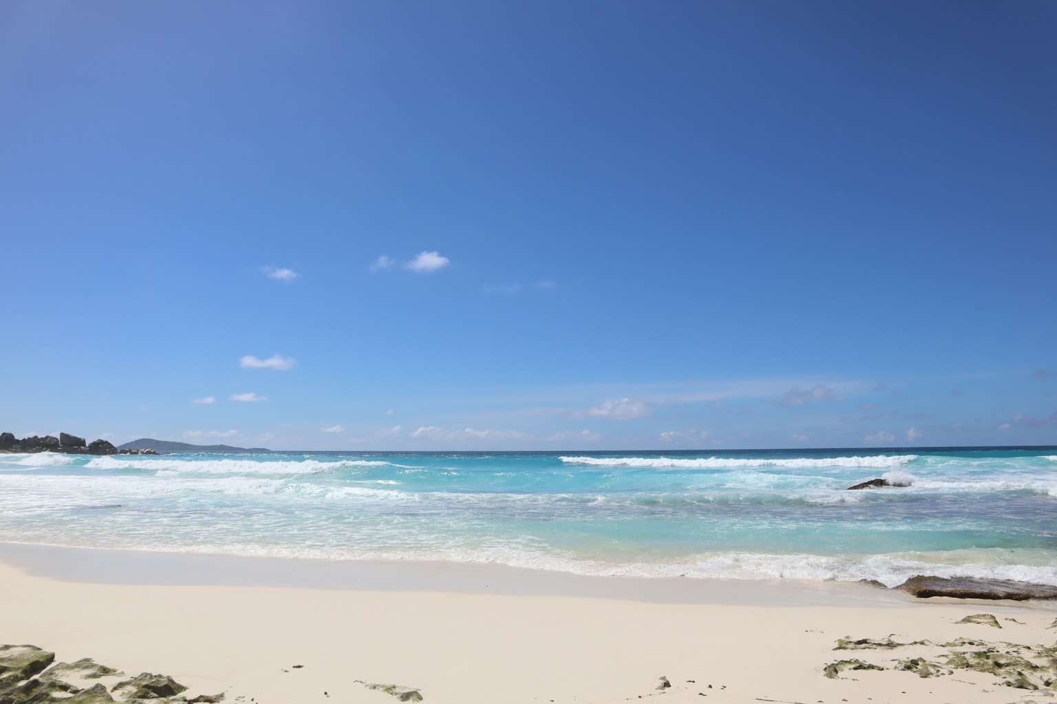 Vue panoramique d'une plage avec ciel bleu et vagues