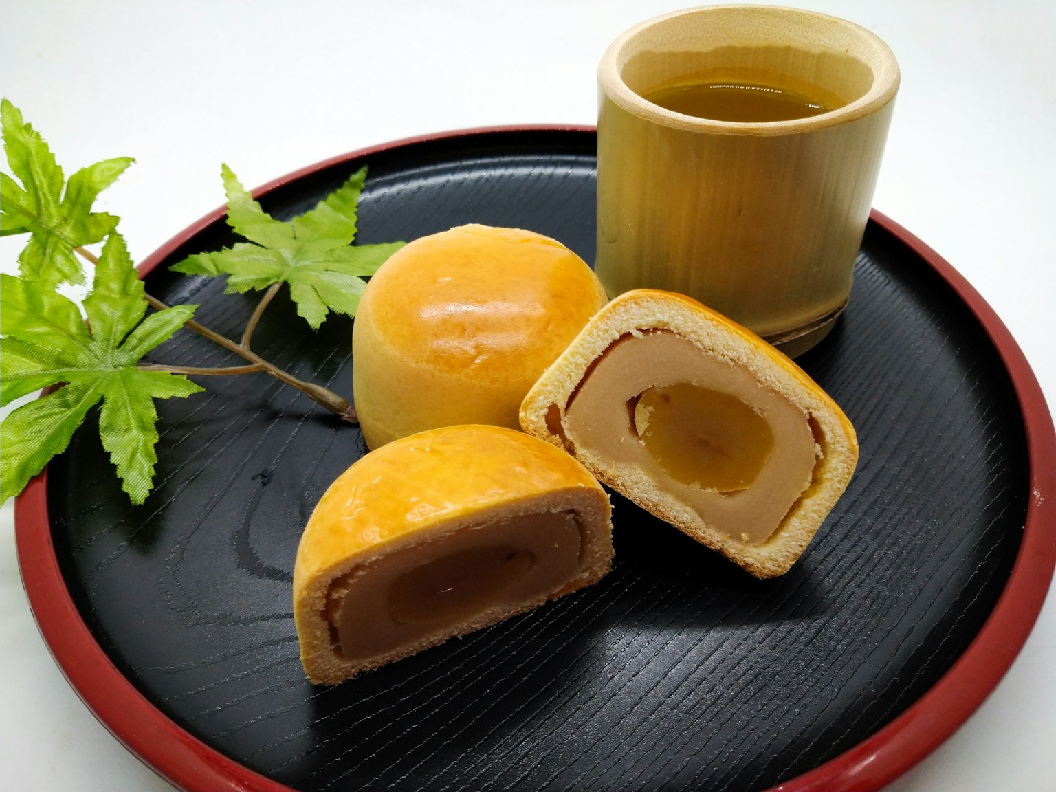 Yellow Japanese sweets and tea on a black plate