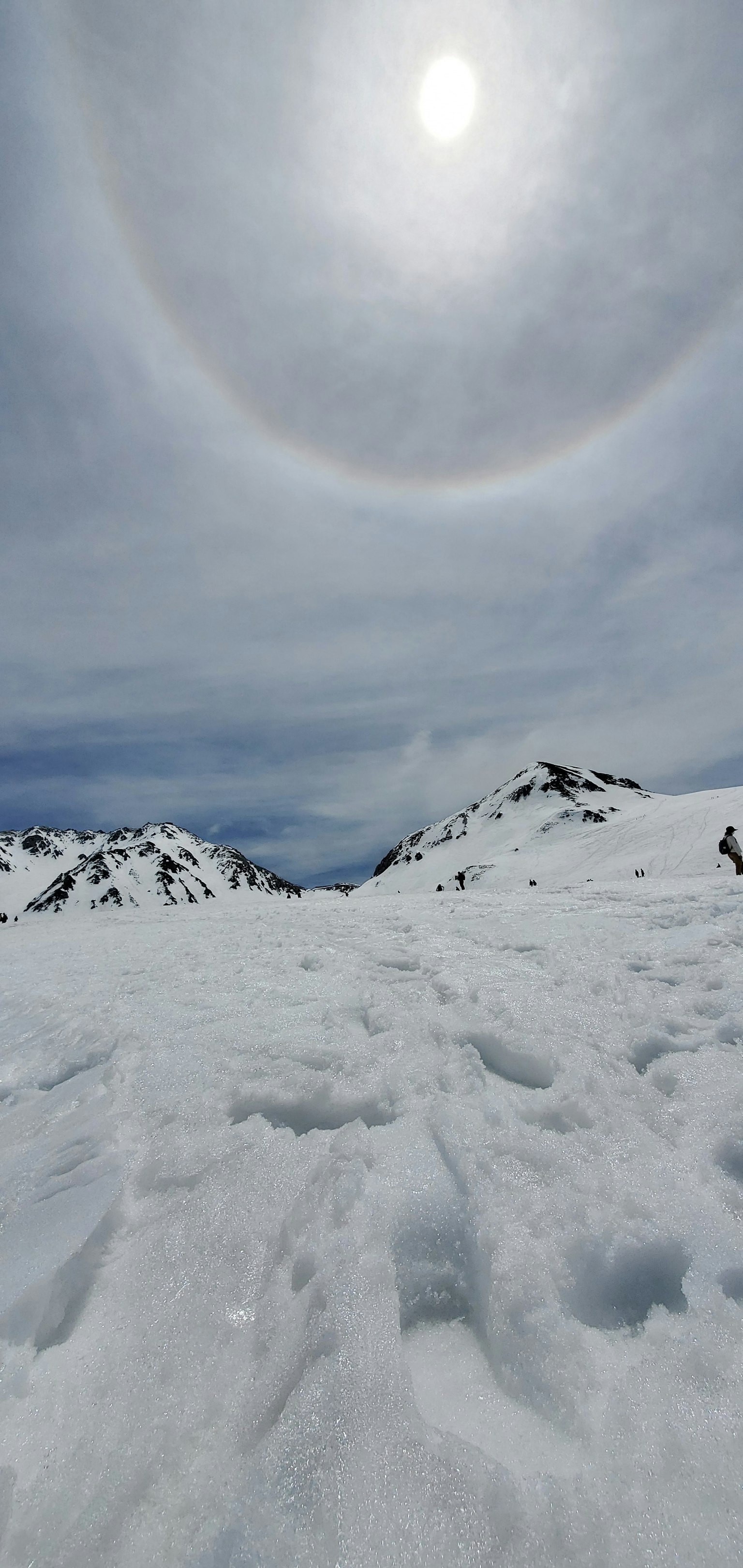 Schneebedeckte Landschaft mit Sonne und einem Halo darum