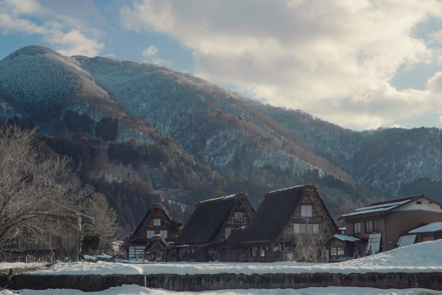 Snowy Shirakawa-go gassho-zukuri village with mountain ridges
