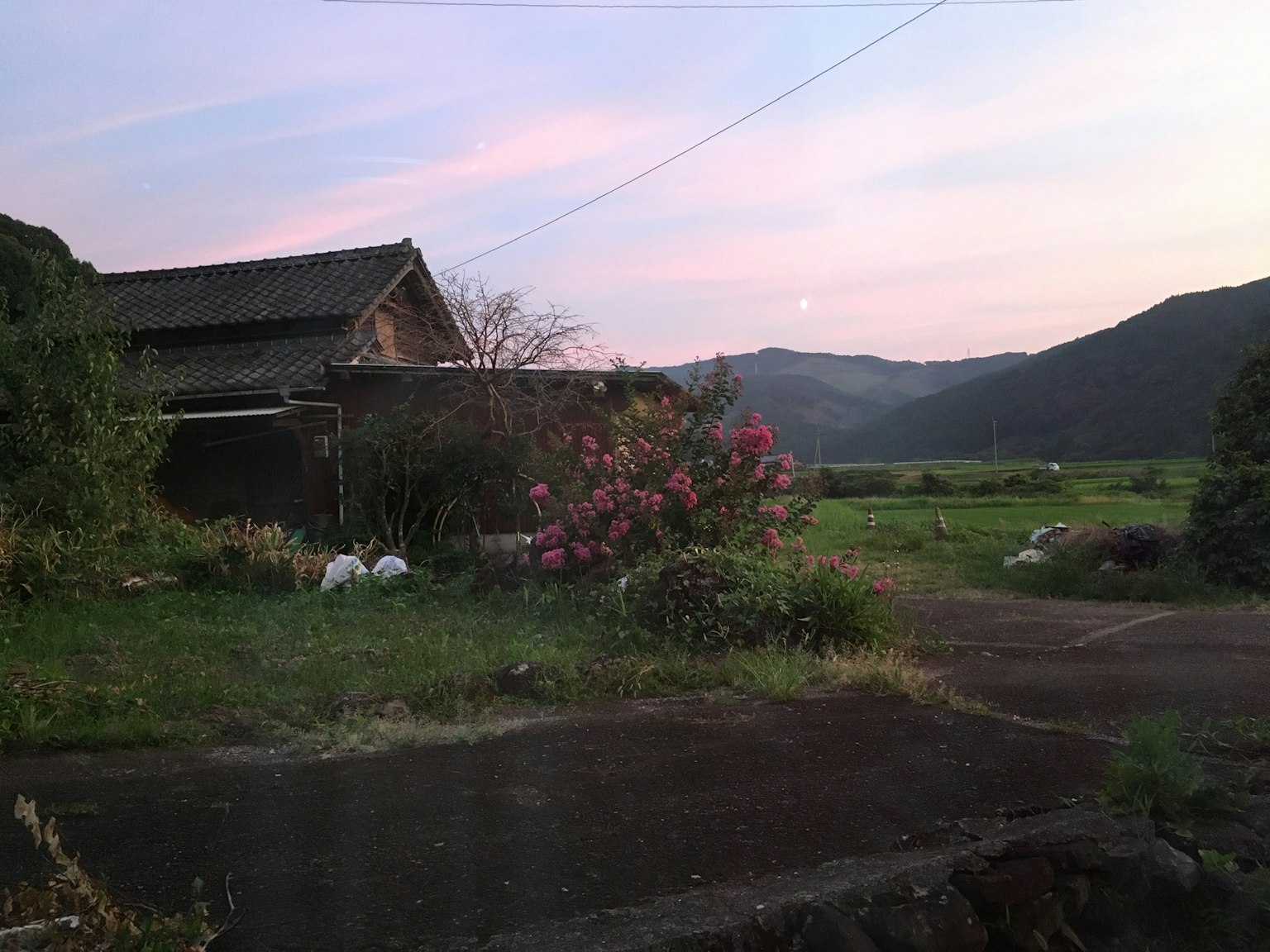 ทิวทัศน์ชนบทที่มีบ้านเก่าและดอกไม้หลากสี