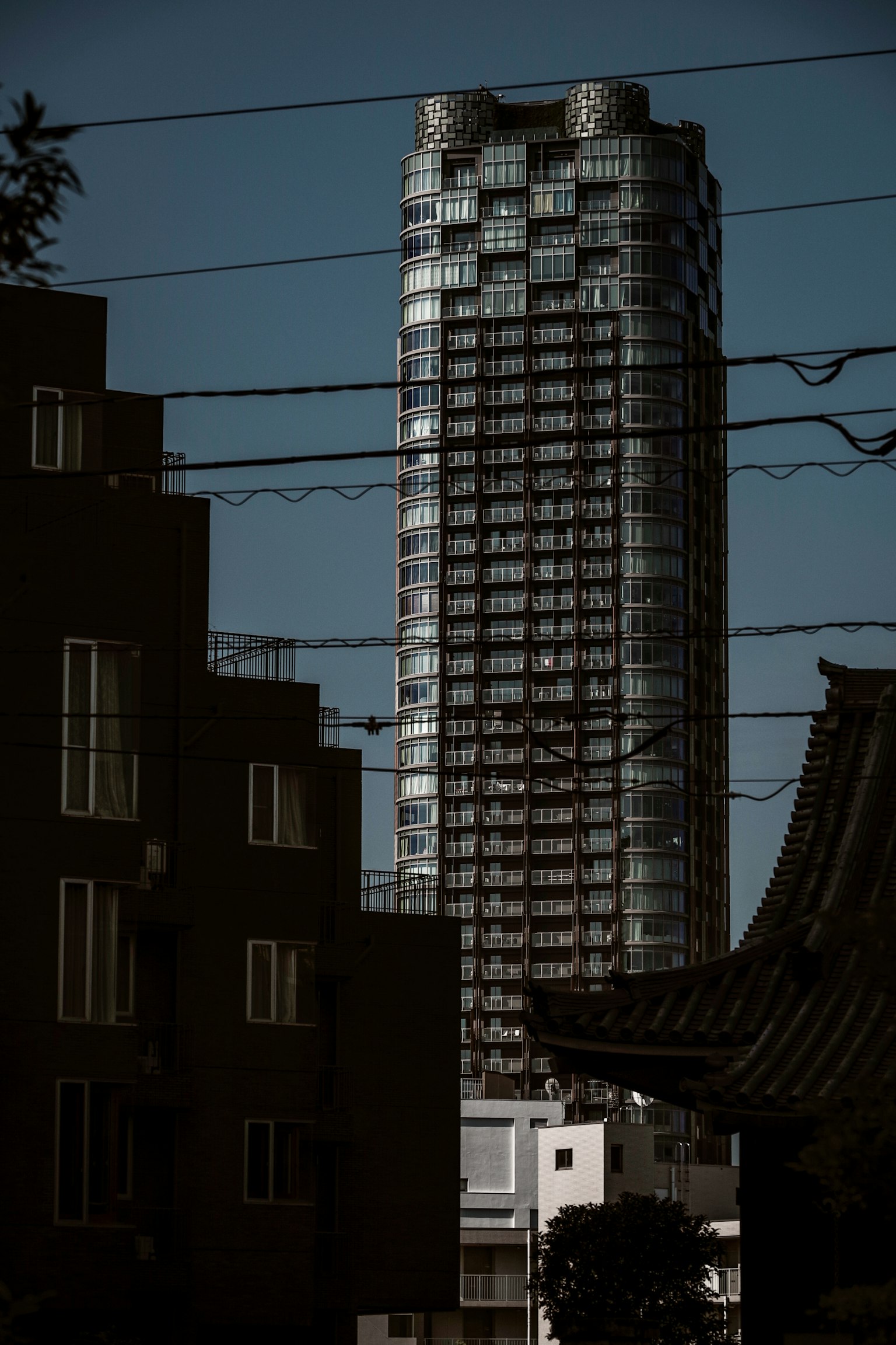 一座摩天大楼在夜景中高耸于周围建筑之后