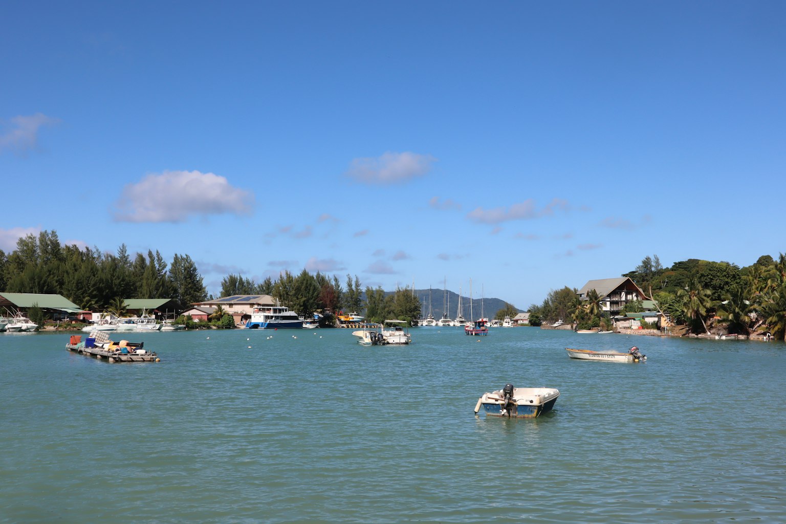 Malerscher Blick auf kleine Boote auf ruhigem Wasser mit üppigem Grün am Ufer