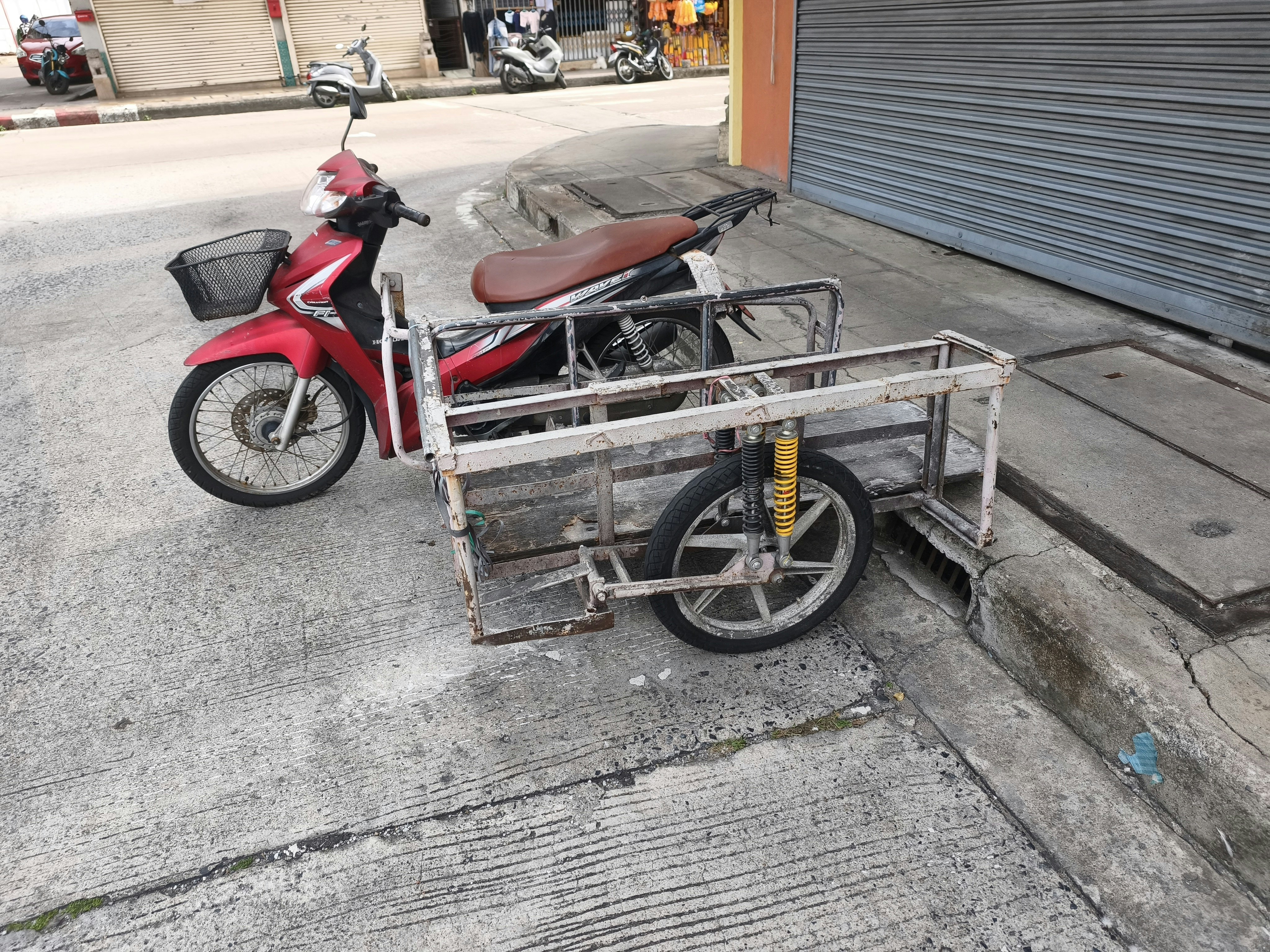 路地の軒先に停められたバイクと荷台付き自転車