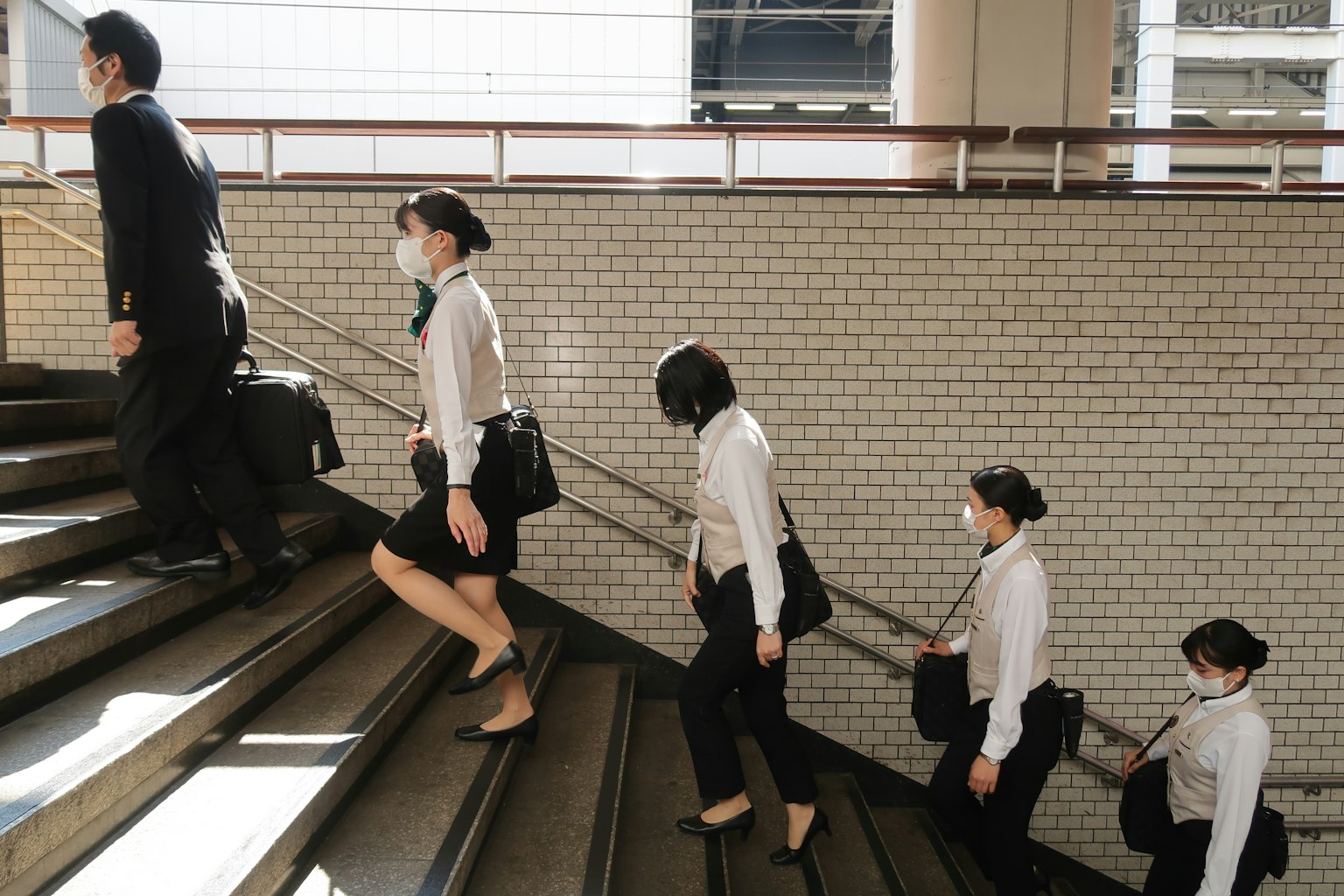 Group of men and women in business attire ascending stairs