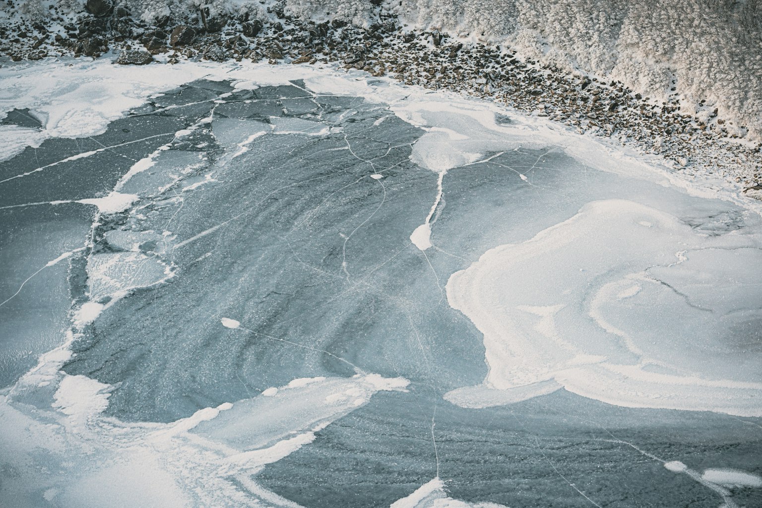 Muster von blauer Wasseroberfläche mit weißem Schaum auf Eis