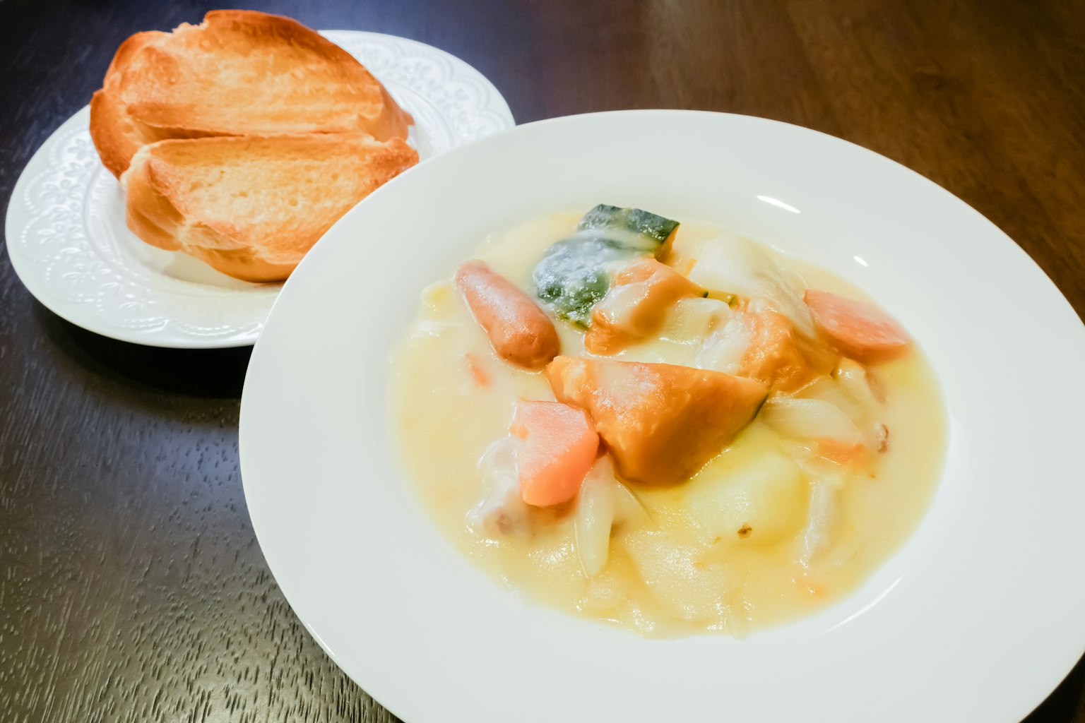Soupe crémeuse avec des légumes servie avec du pain