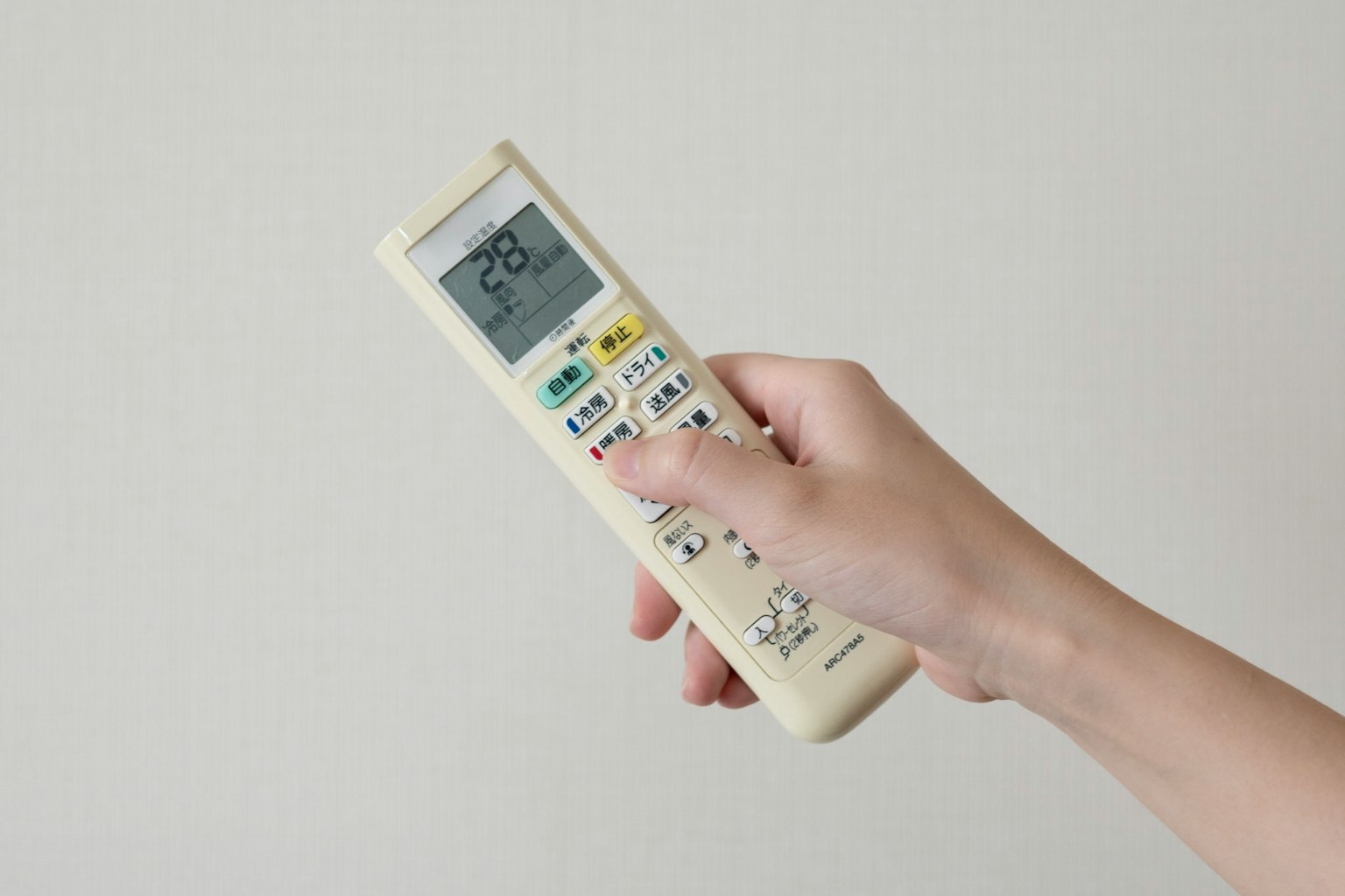 Hand hält eine Fernbedienung Weißer Hintergrund Temperaturanzeige