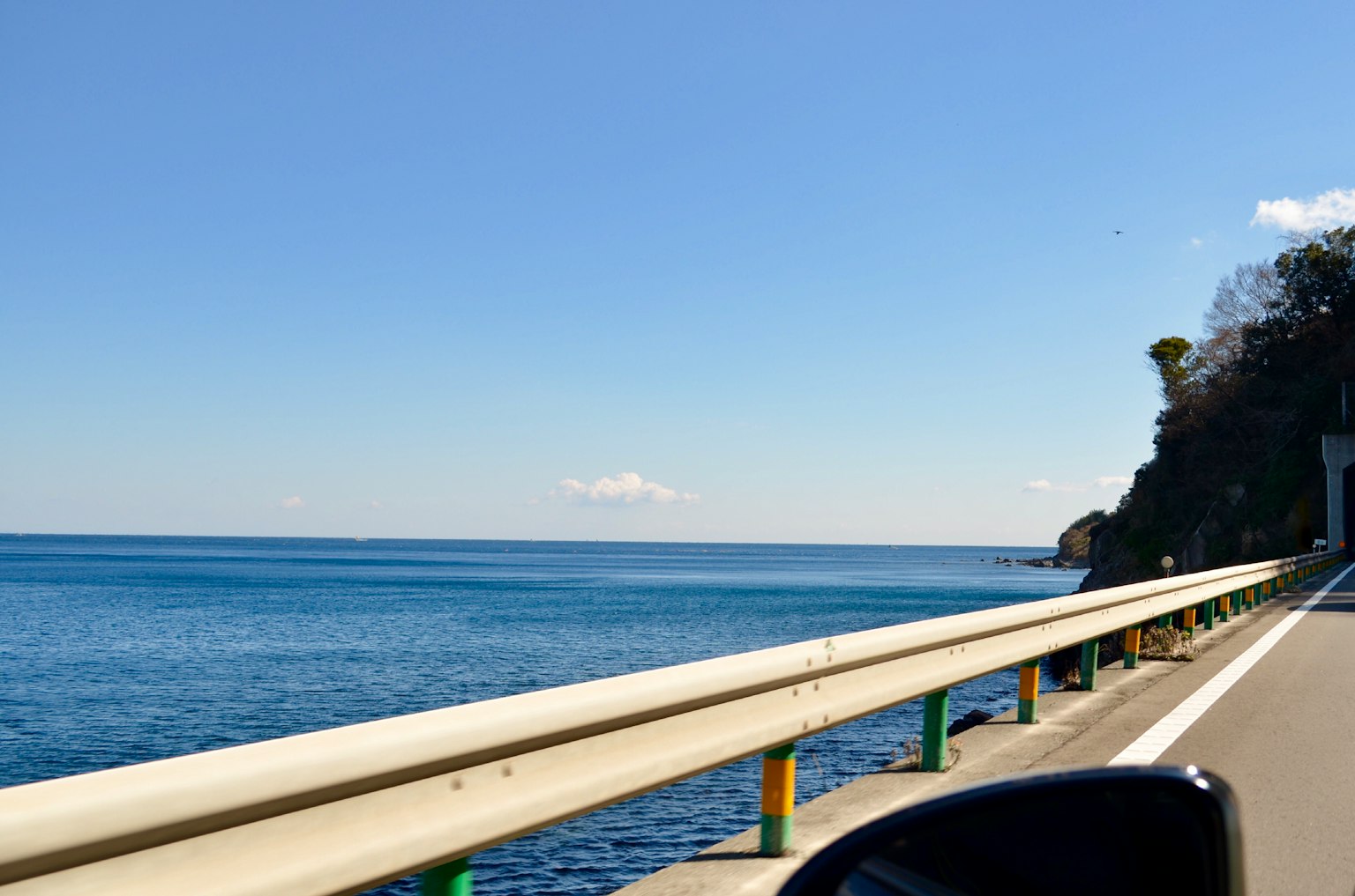 Jalan pesisir dengan laut biru dan langit cerah