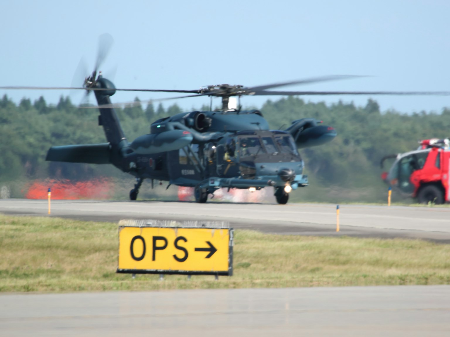 Ein Hubschrauber auf der Landebahn mit einem OPS-Schild, das nach rechts zeigt