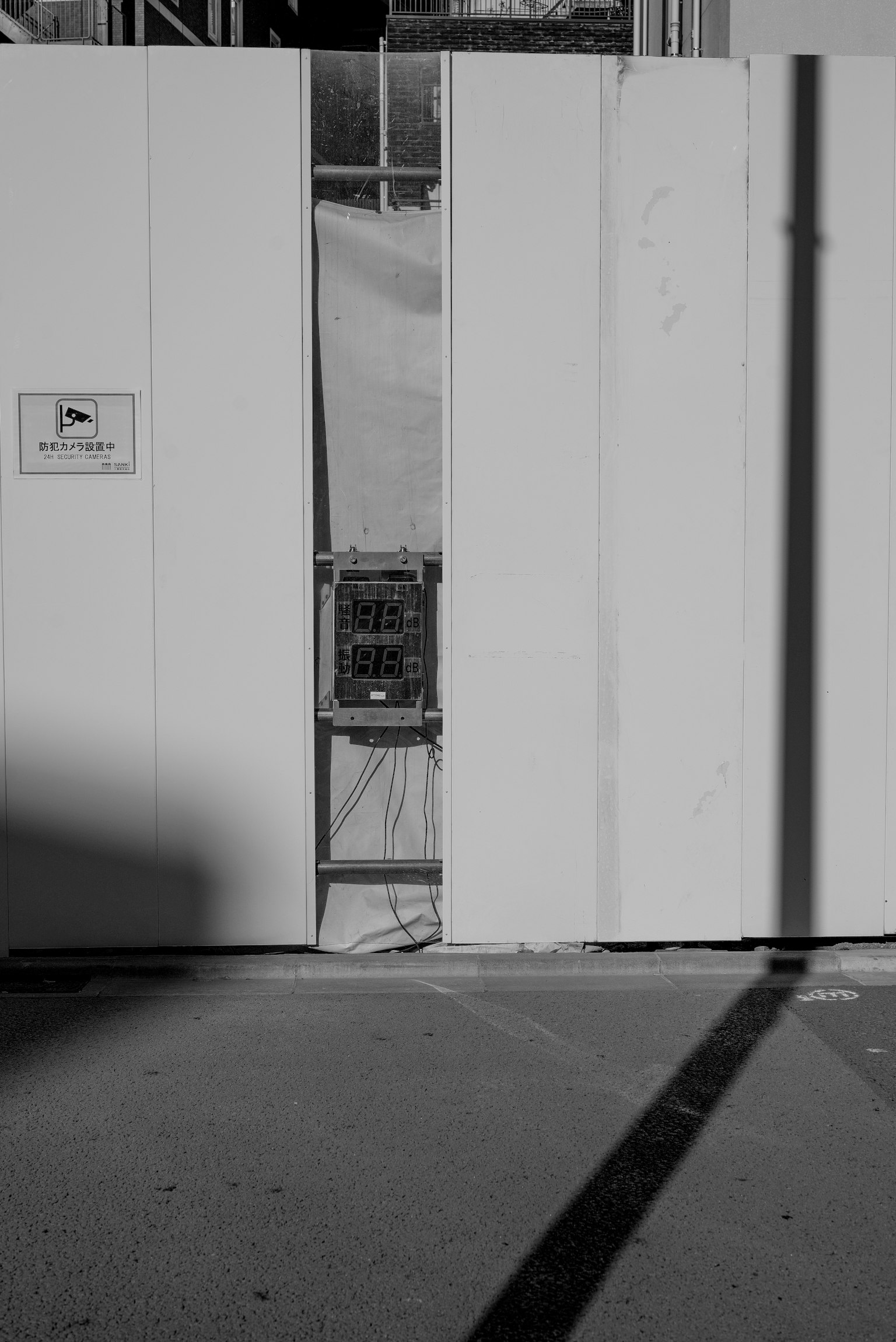 Sebuah kotak hitam terlihat melalui dinding putih dengan bayangan