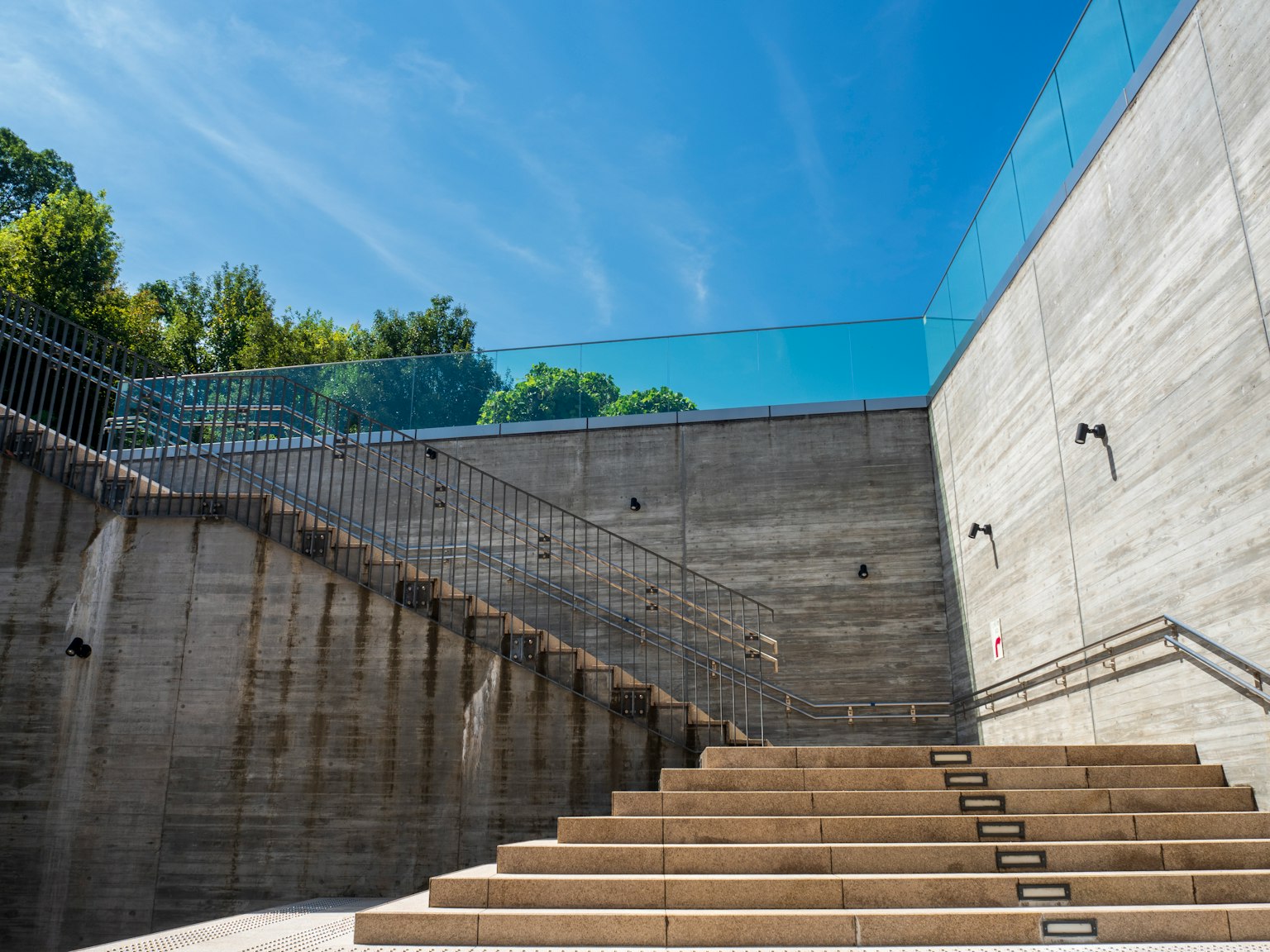 Modern architecture featuring concrete stairs and glass railing