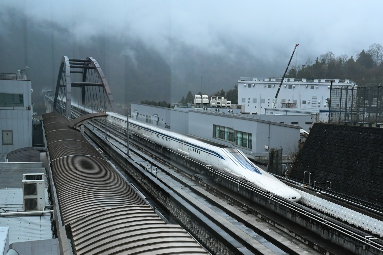 Tren Shinkansen pasando rápidamente por la niebla con edificios alrededor
