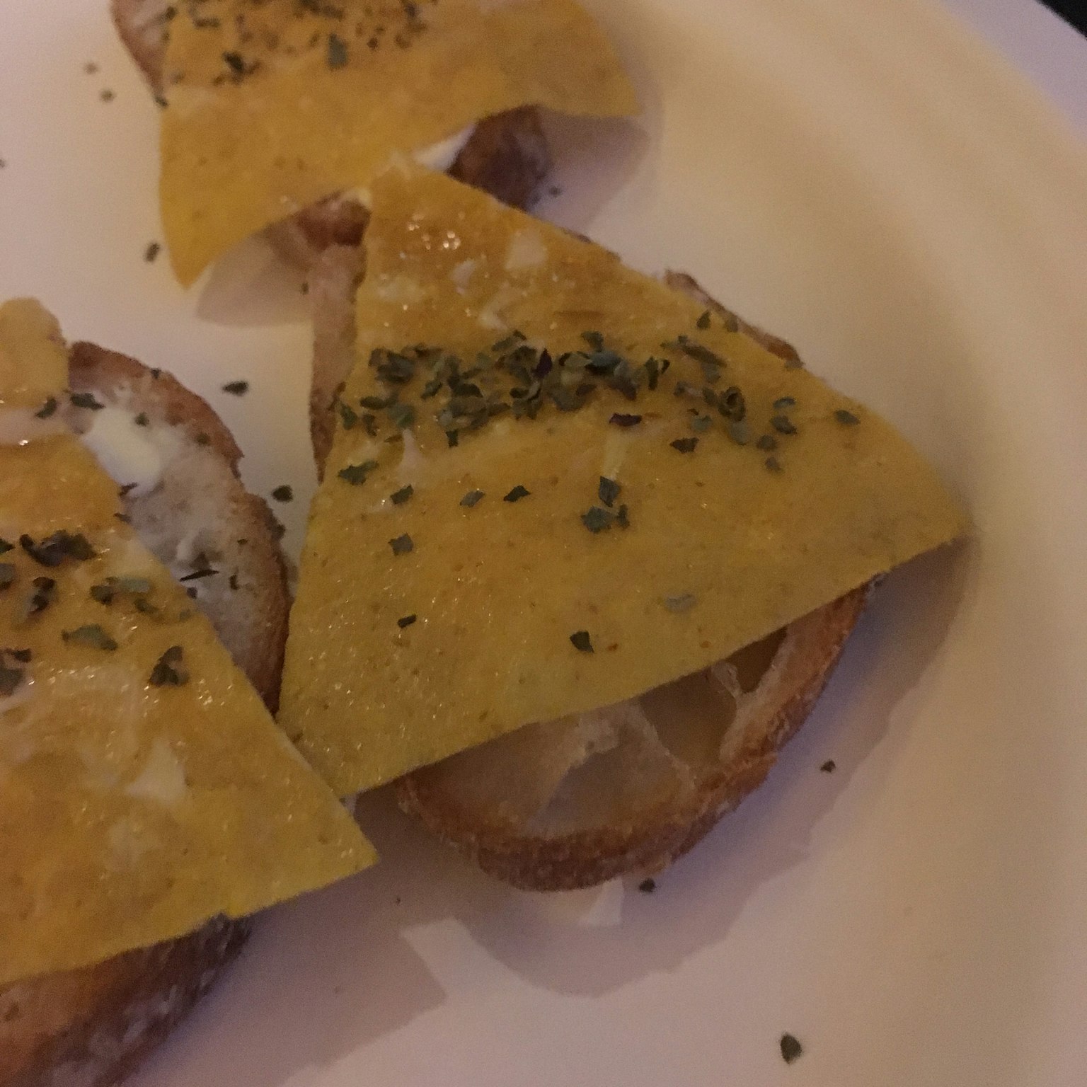 Toast en forme de triangle garni de fromage et d'herbes
