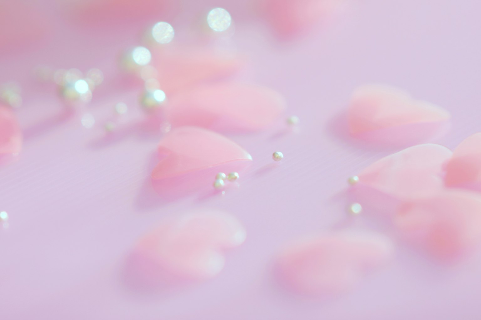 Dekorasi berbentuk hati pink lembut tersebar dengan mutiara di latar belakang terang