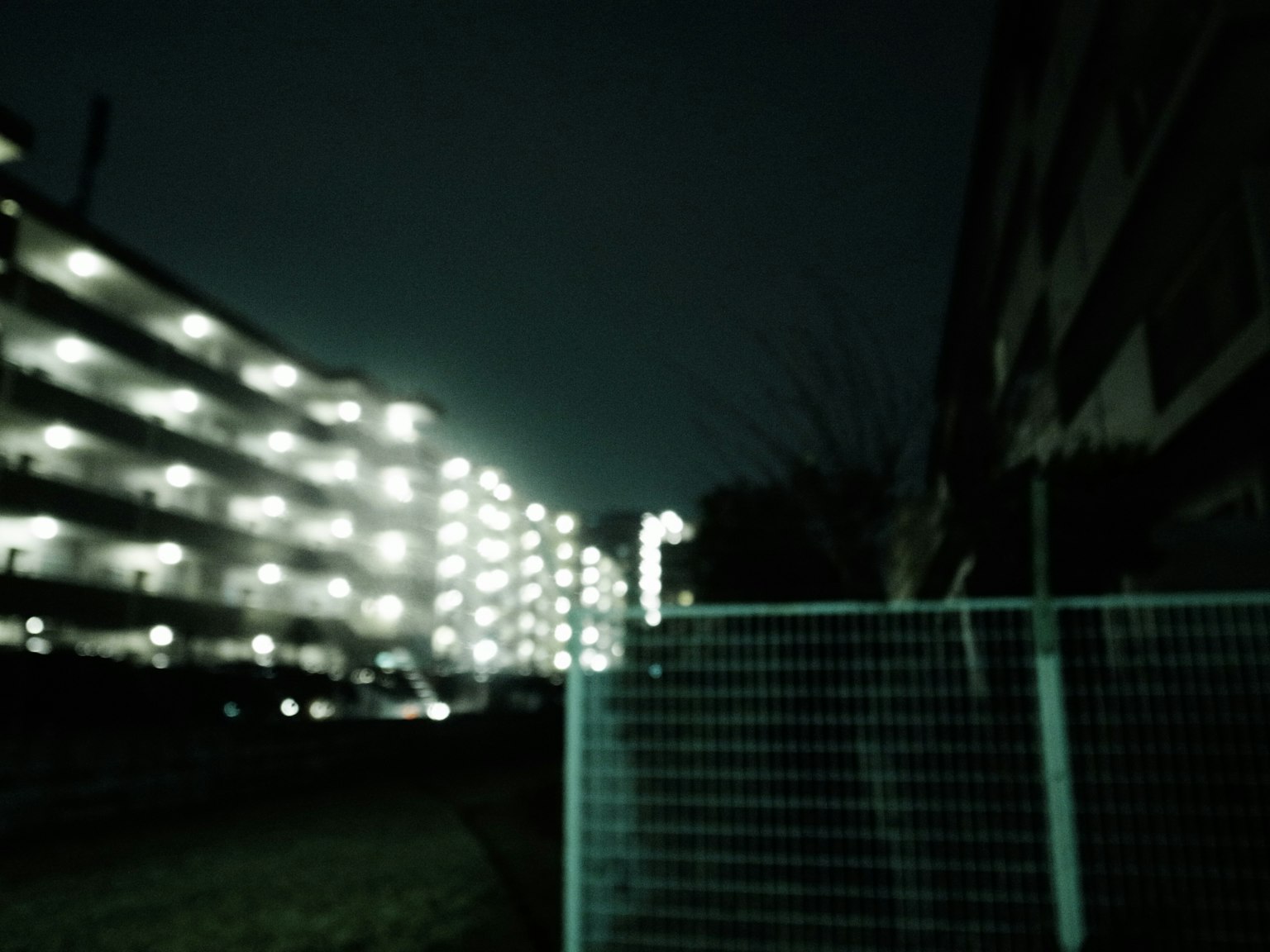 Vista borrosa nocturna de un área residencial con edificios iluminados