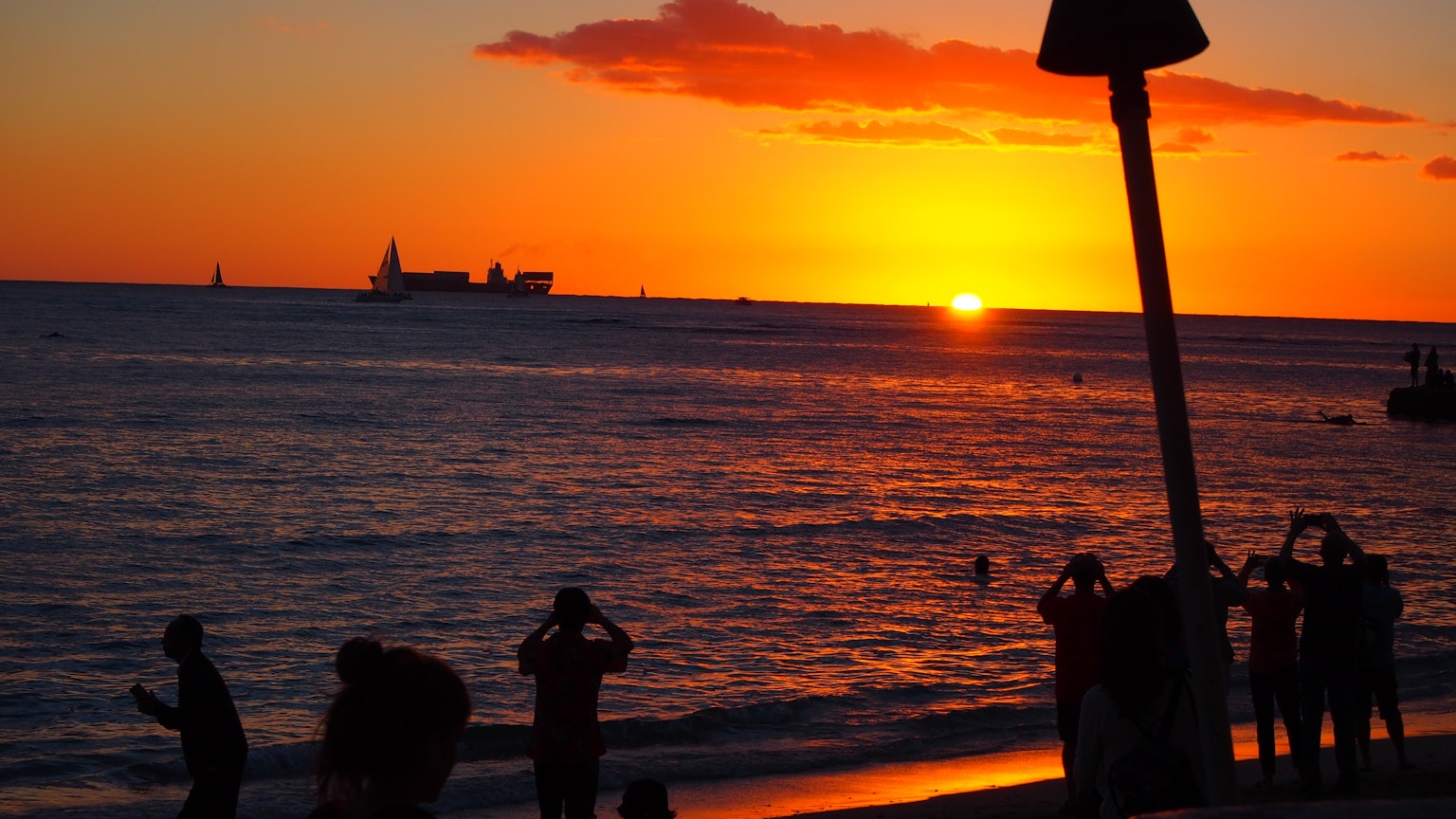 Silhouette di persone sulla spiaggia contro il tramonto
