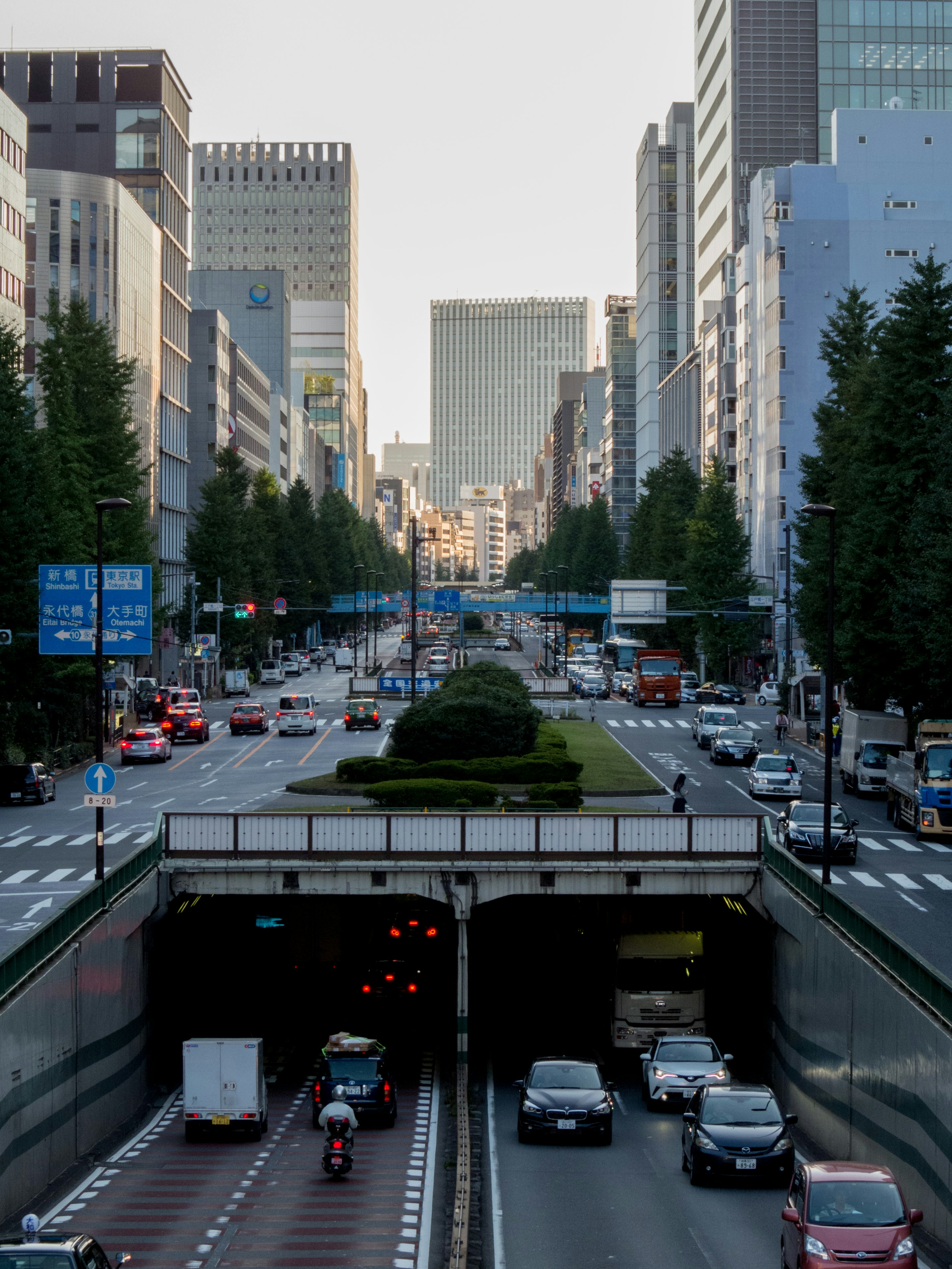 avenida urbana entre altos edificios con un paso elevado